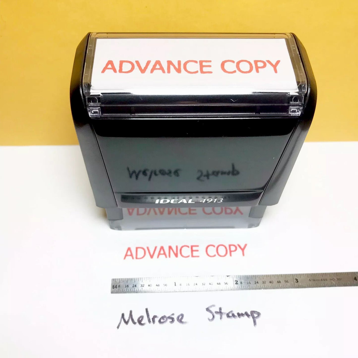 Stamp with 'Advance Copy' text and a ruler for scale on a yellow and white background