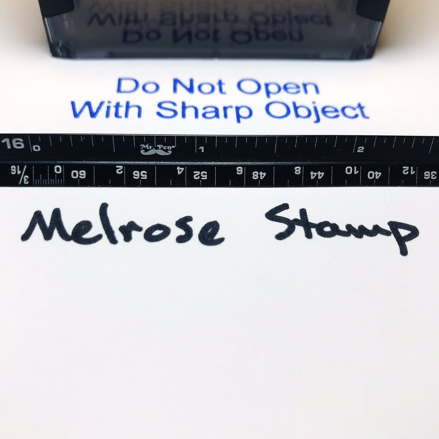Melrose stamp with text 'Do Not Open With Sharp Object' and a ruler below.