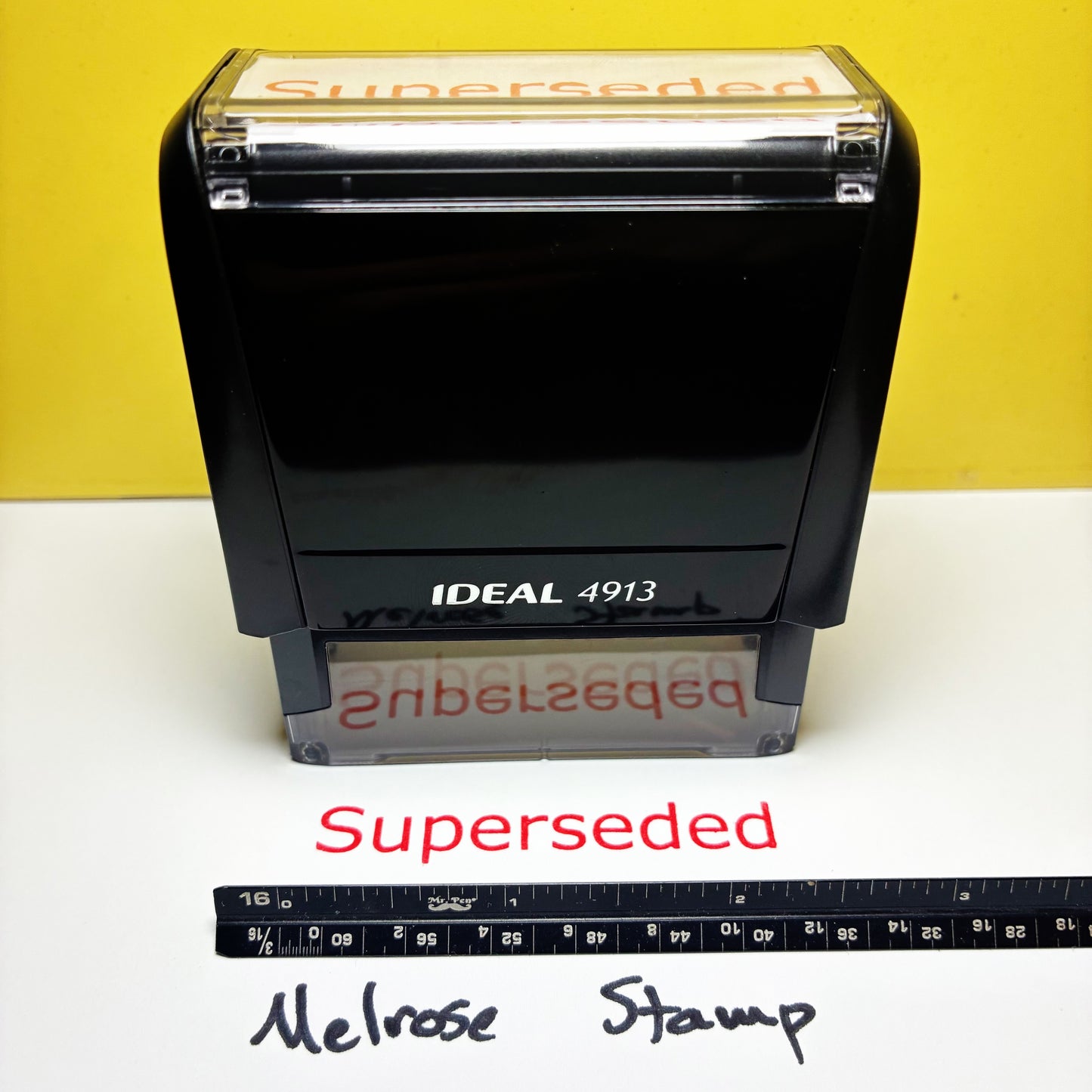 Rubber stamp with 'Superseded' text on a yellow and white background, accompanied by a ruler for scale.