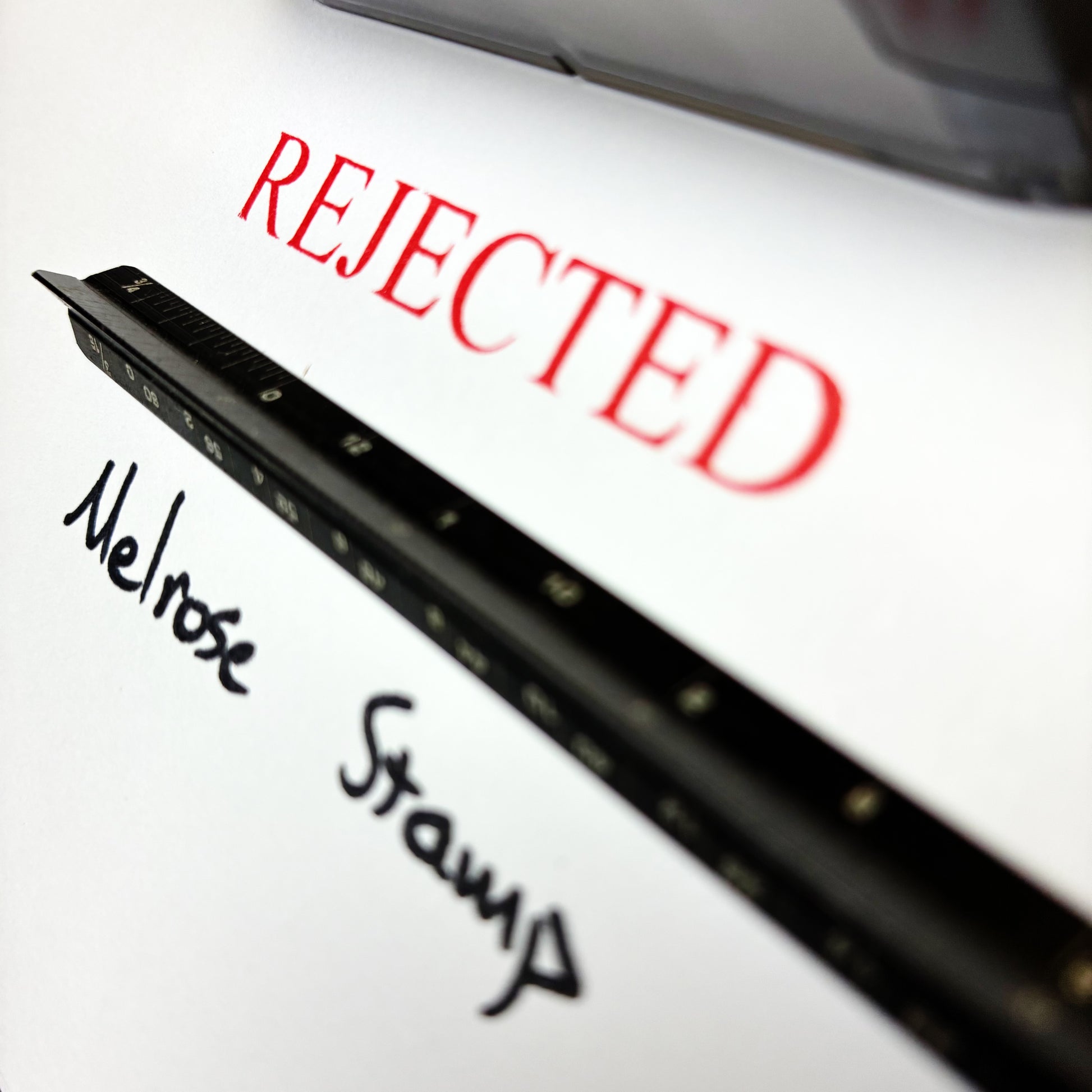 Rubber stamp with 'REJECTED' in red and 'Melrose Stamp' in black on a white background
