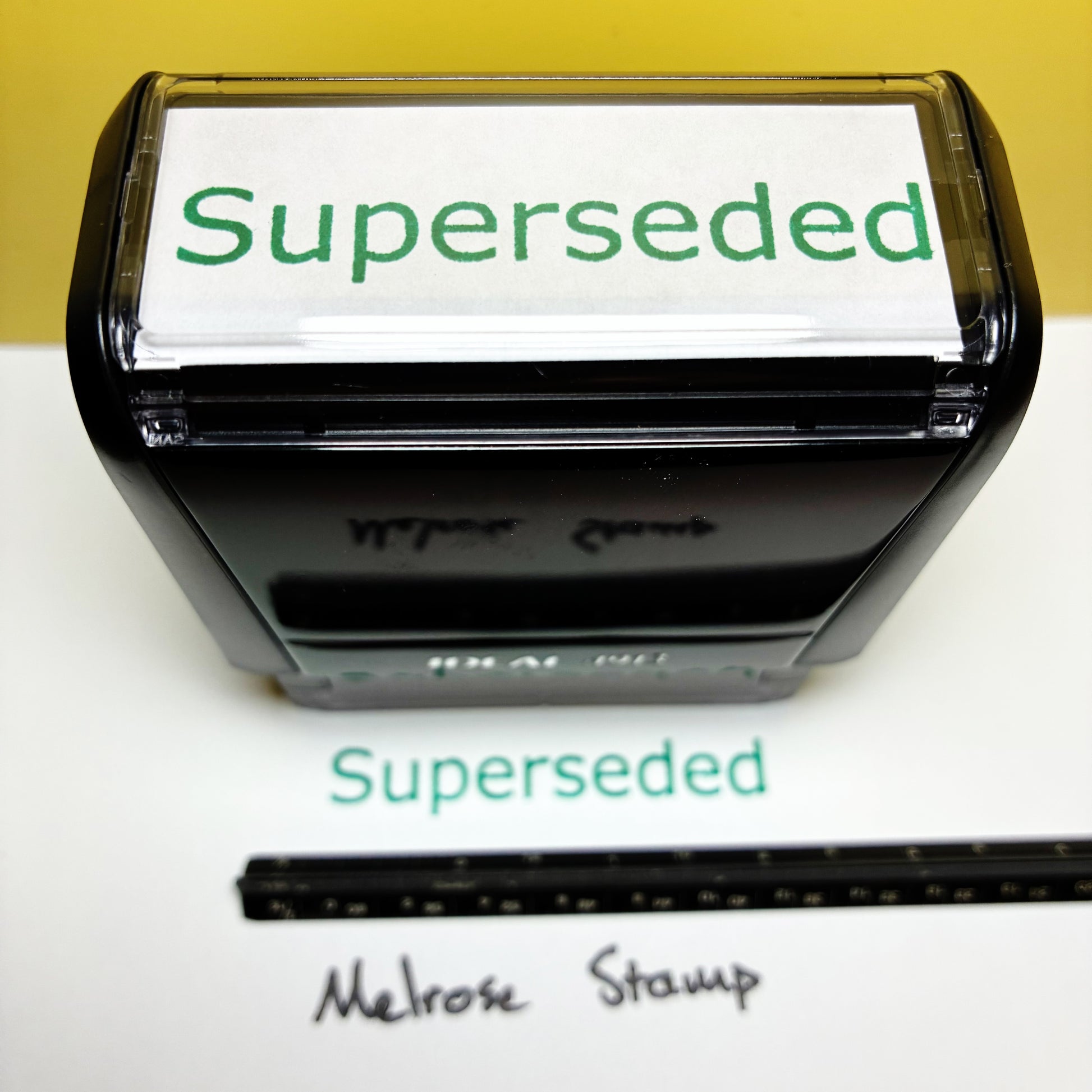 Black stamp with 'Superseded' text on a white background rubber stamp green ink