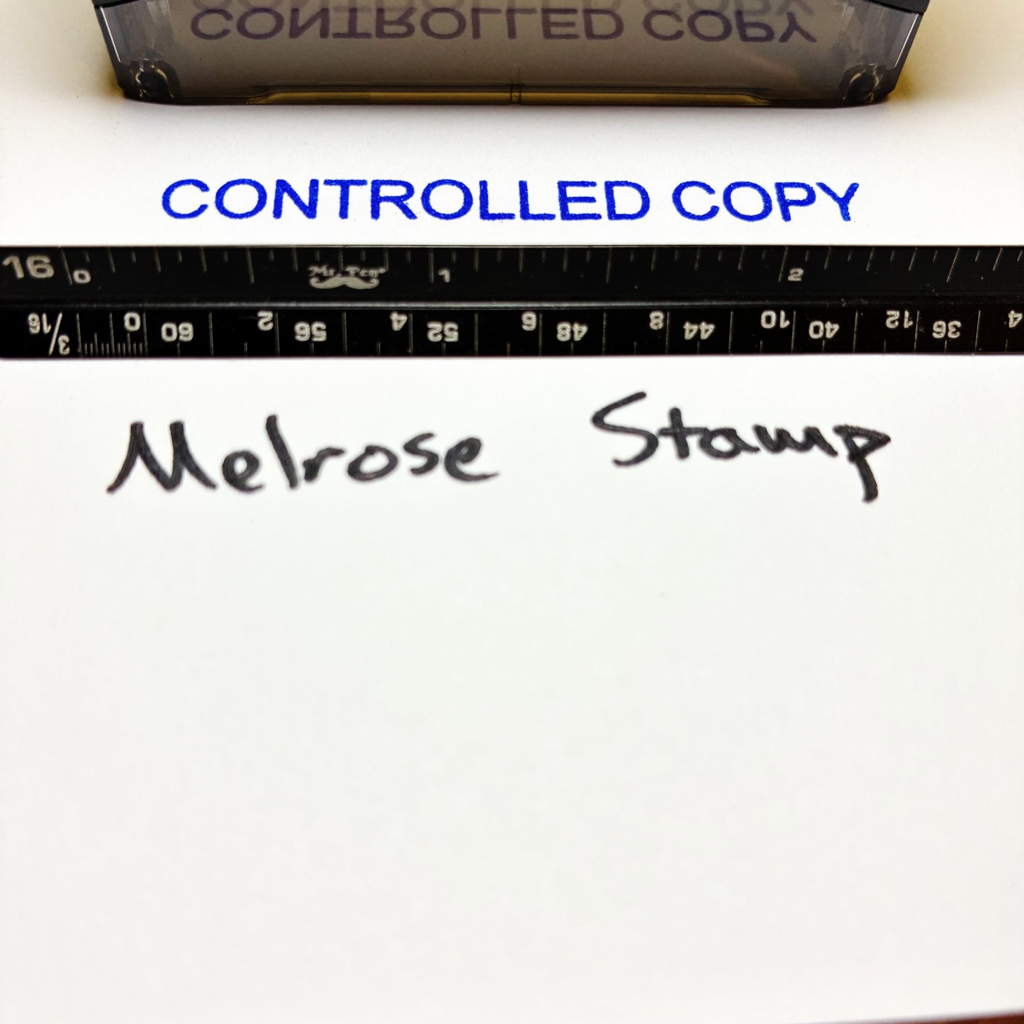 Text 'CONTROLLED COPY' and 'Melrose Stamp' on a white surface with a ruler.
