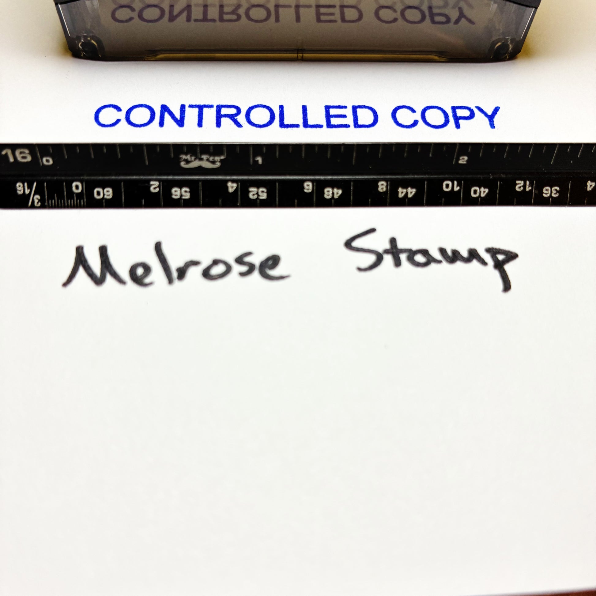 Text 'CONTROLLED COPY' and 'Melrose Stamp' on a white surface with a ruler.