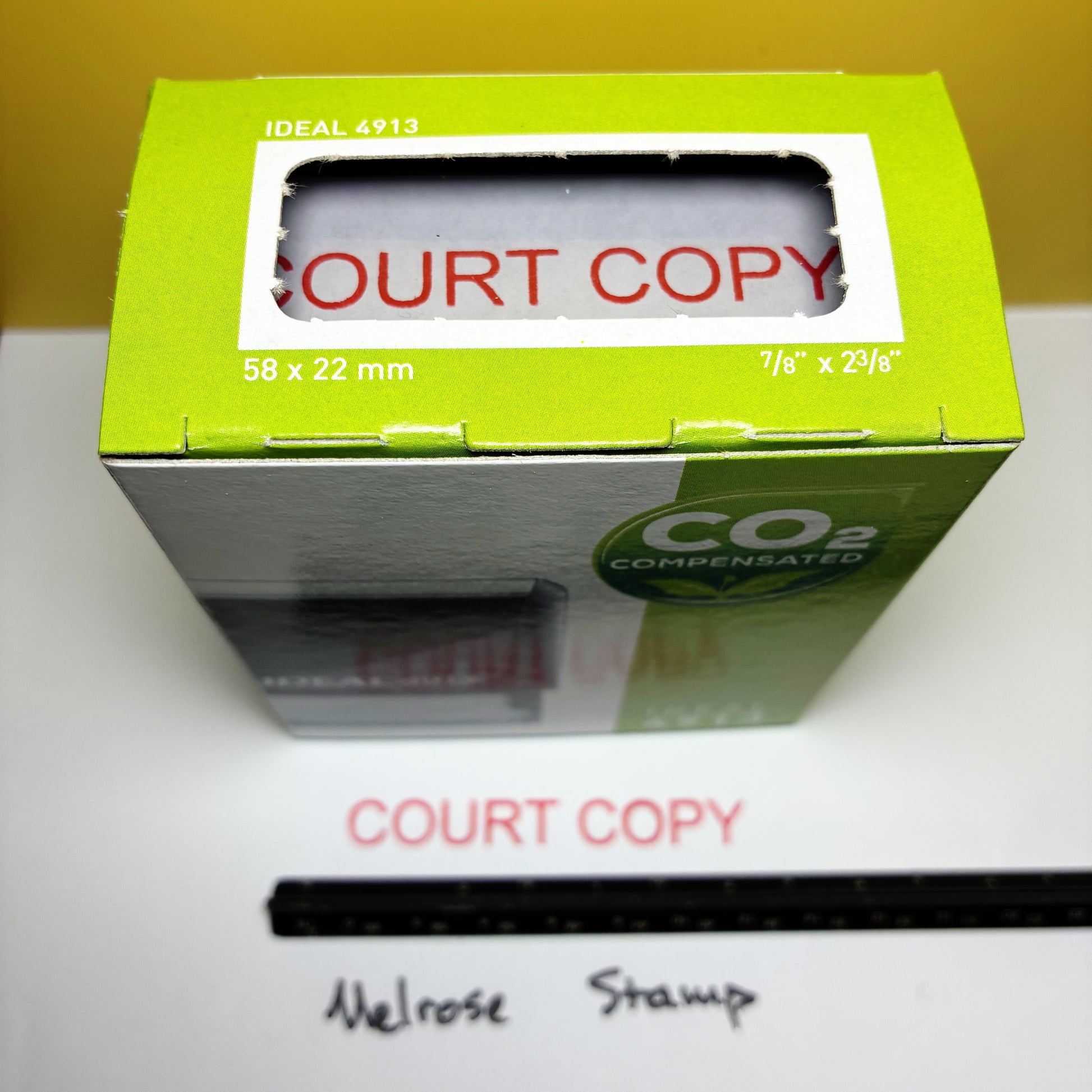 Green box labeled 'Court Copy' with a white label inside, on a white surface rubber stamp red ink