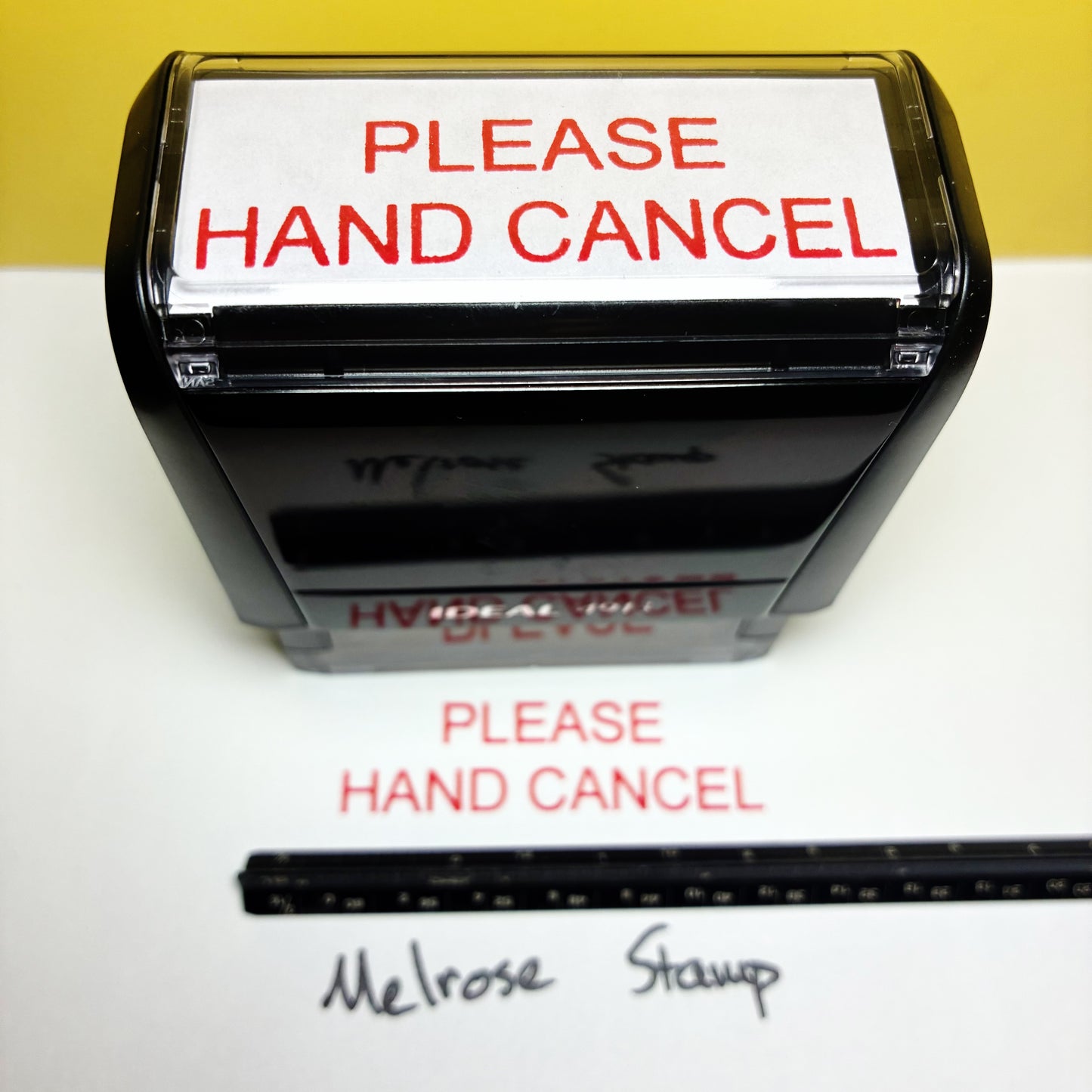 Rubber stamp with 'PLEASE HAND CANCEL' text on a white background