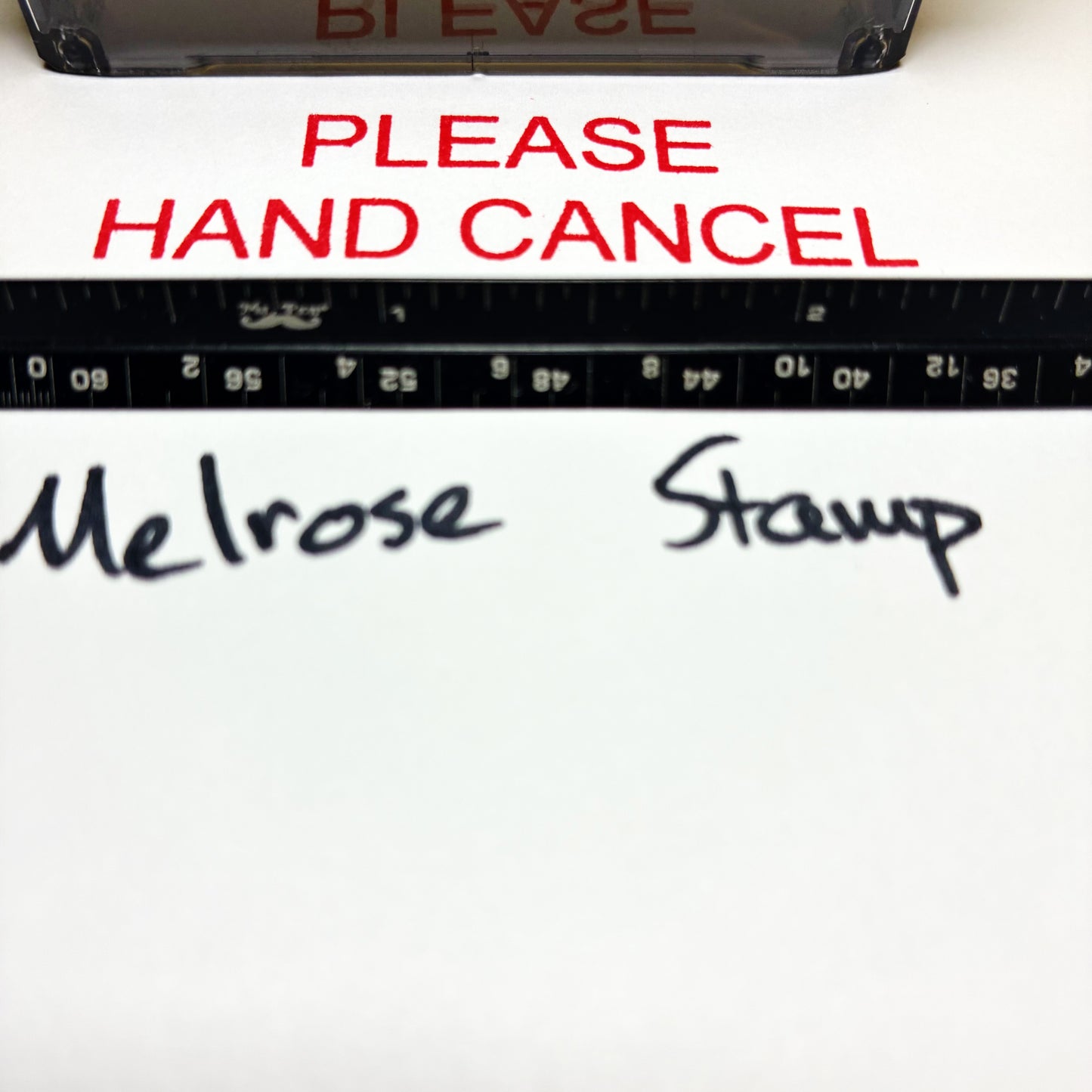 Text 'PLEASE HAND CANCEL' in red above a ruler with measurements, and 'Melrose Stamp' written below.