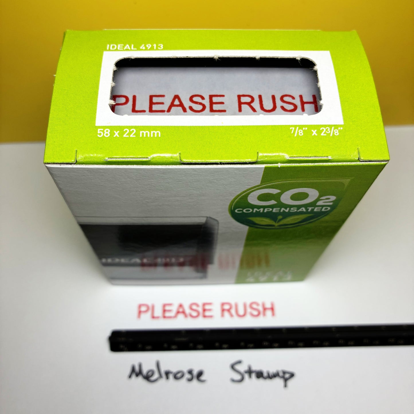 Green box with 'Please Rush' label on a white surface rubber stamp red ink