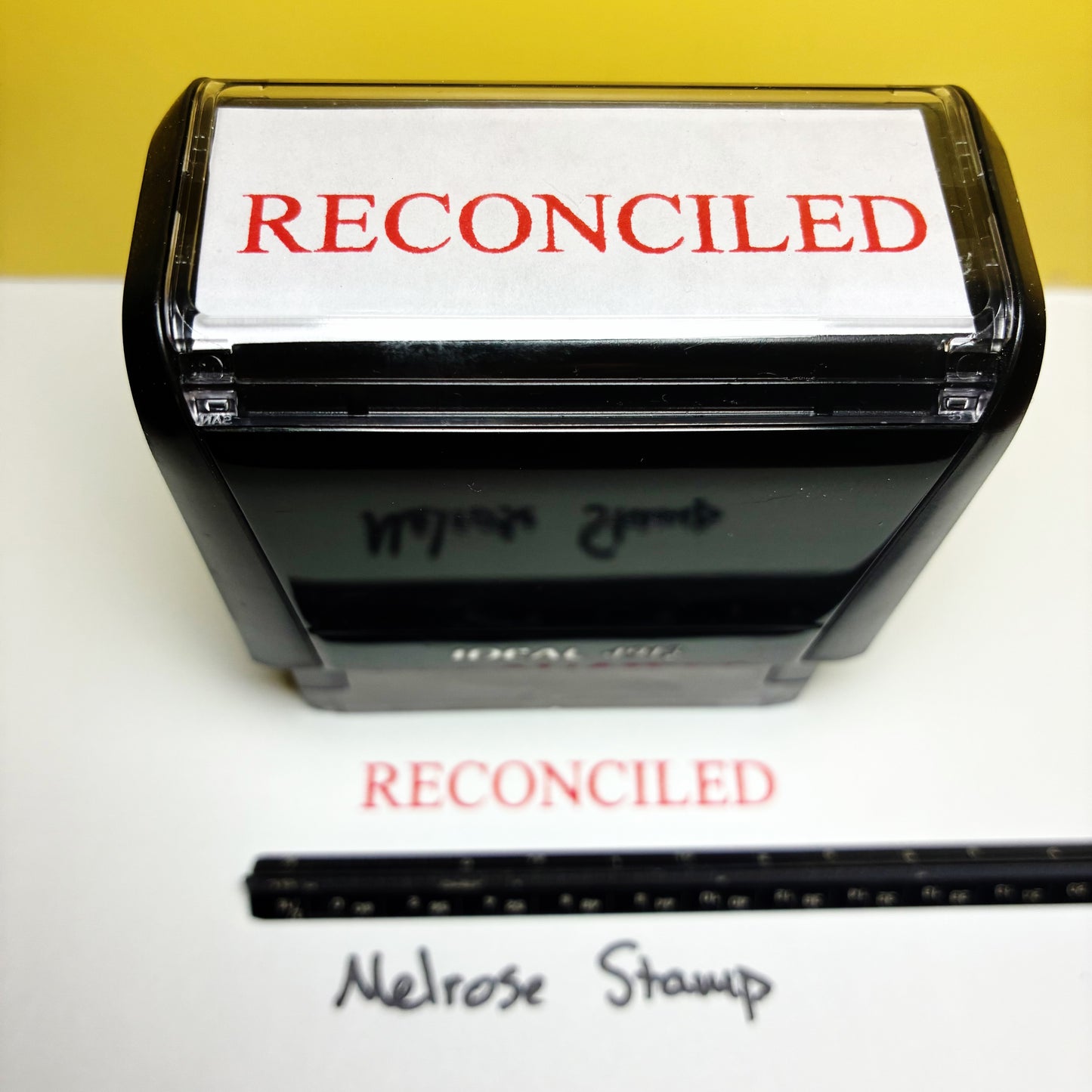 Rubber stamp with 'RECONCILED' text on a white background
