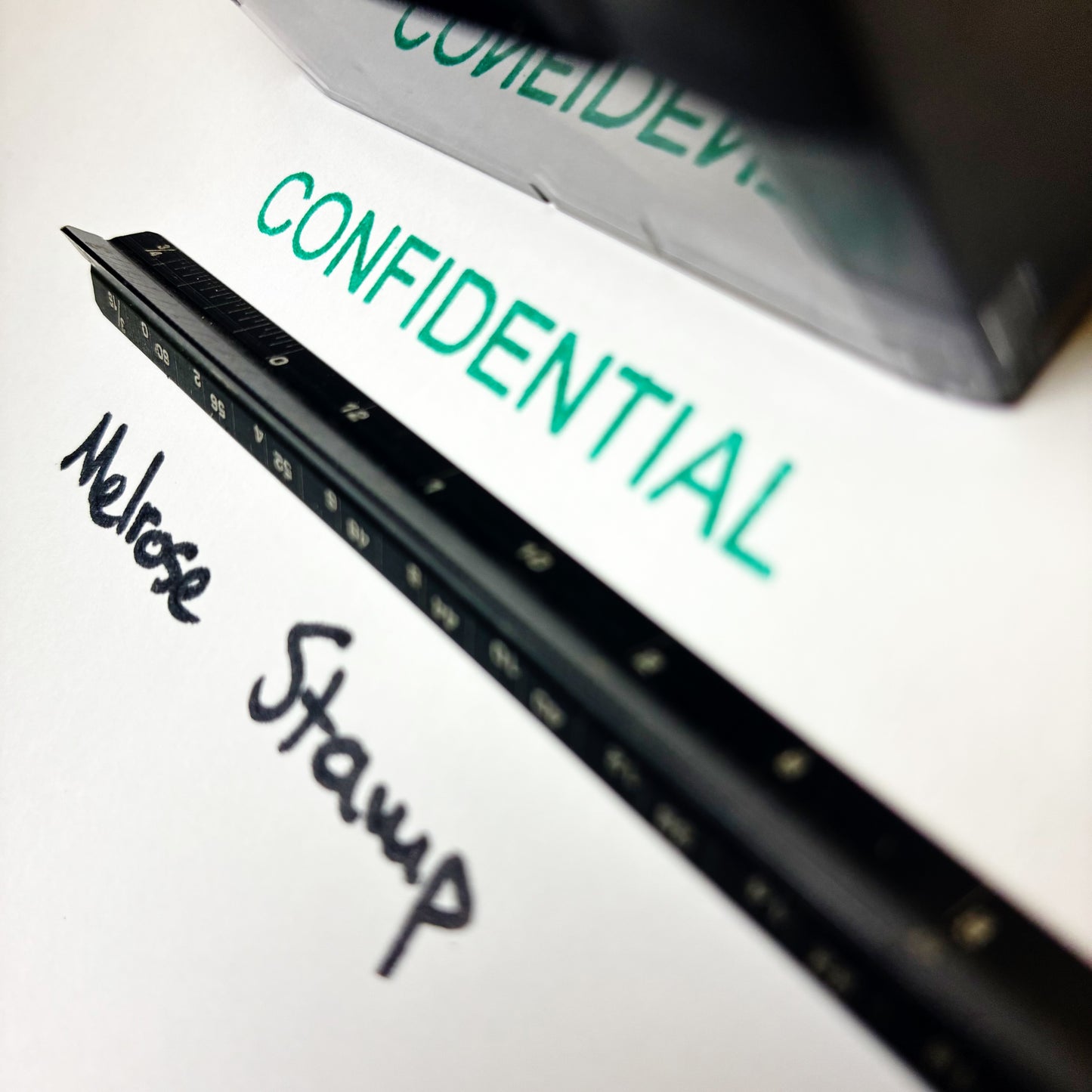 Close-up of a document with 'CONFIDENTIAL' rubber stamp self-inking green ink