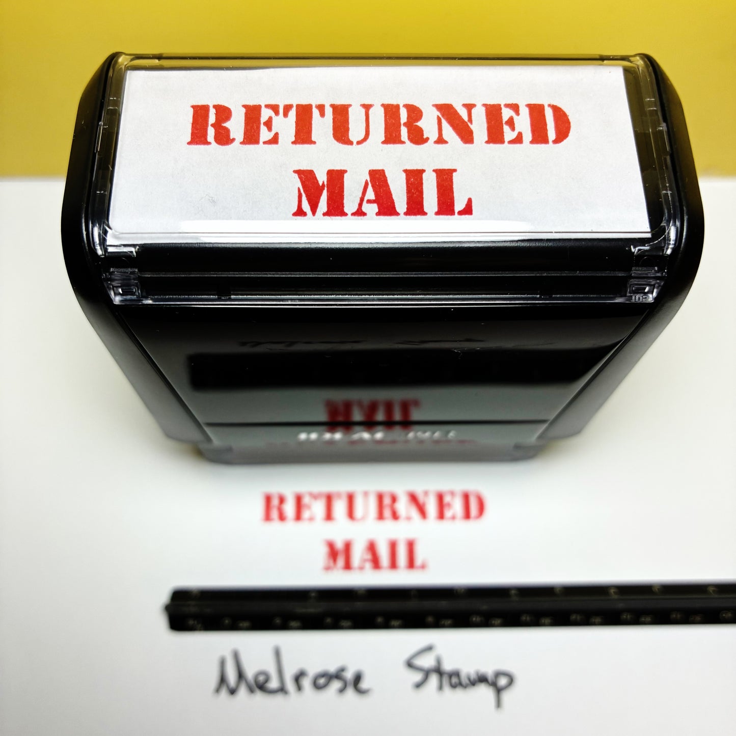 Rubber stamp with 'RETURNED MAIL' text on a white background