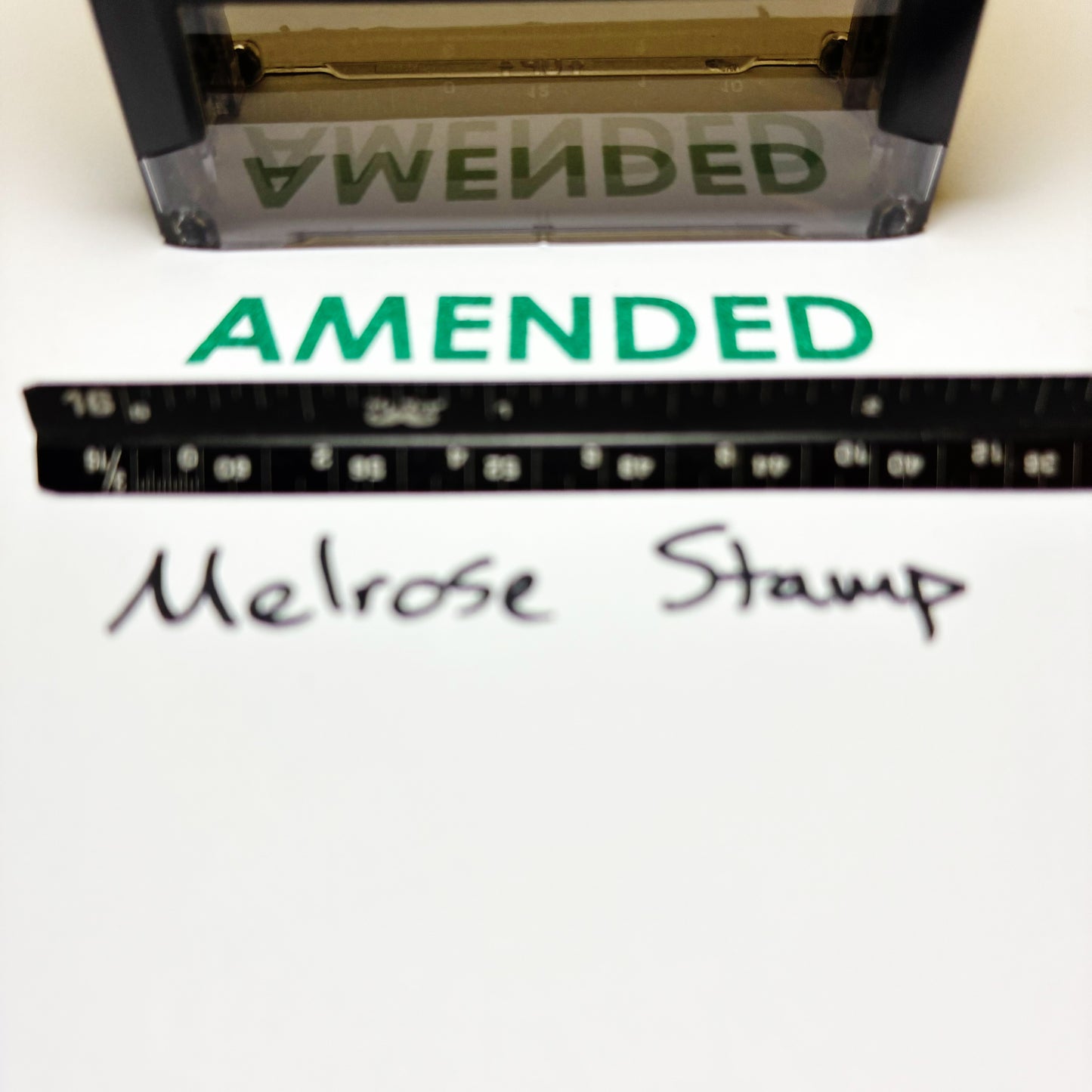 Amended stamp green ink with a ruler and 'Melrose Stamp' text on a white background