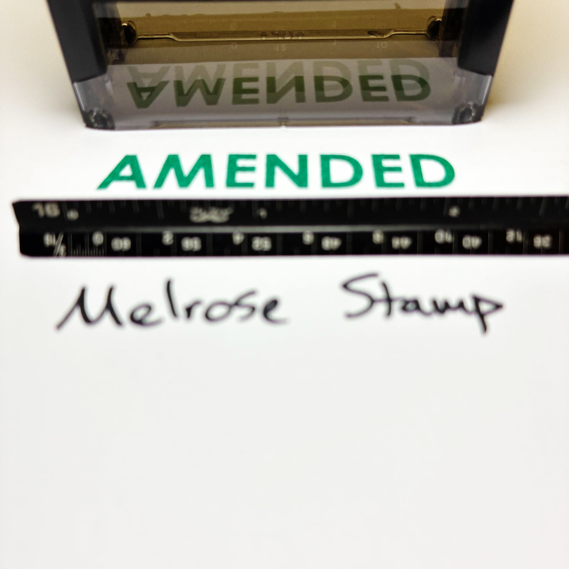 Amended stamp green ink with a ruler and 'Melrose Stamp' text on a white background
