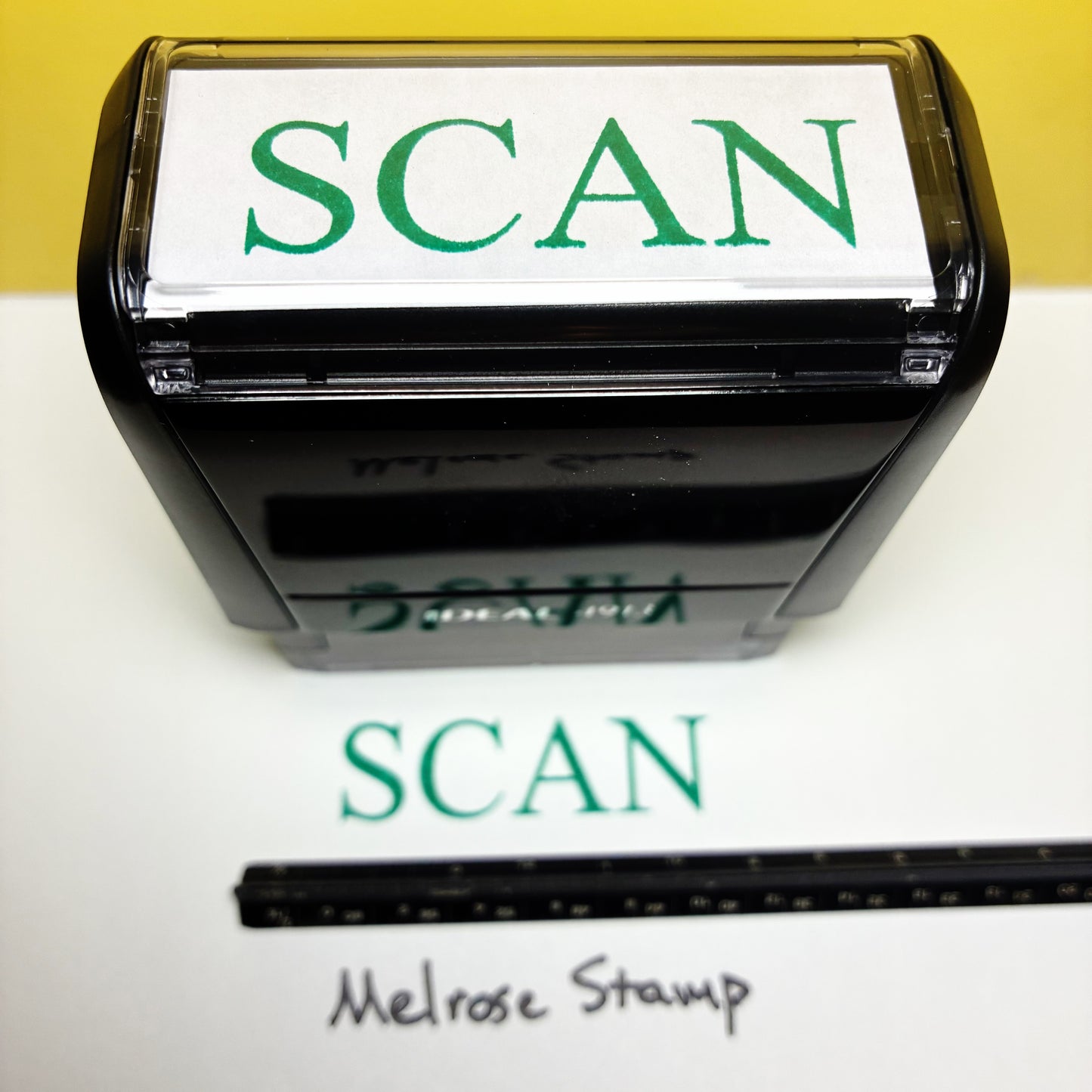 Rubber stamp with 'SCAN' text  green ink on a white background