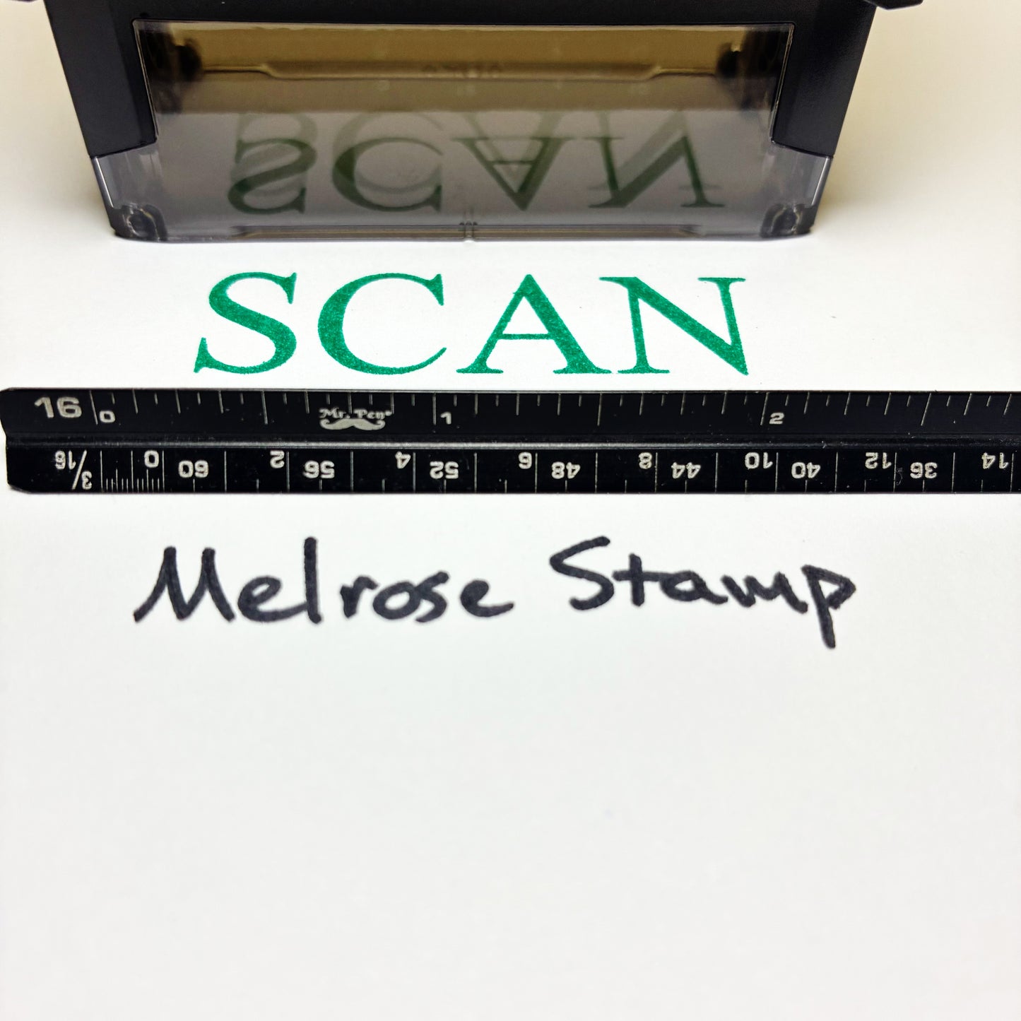 Stamp with 'SCAN' text green ink and a ruler below, on a white background