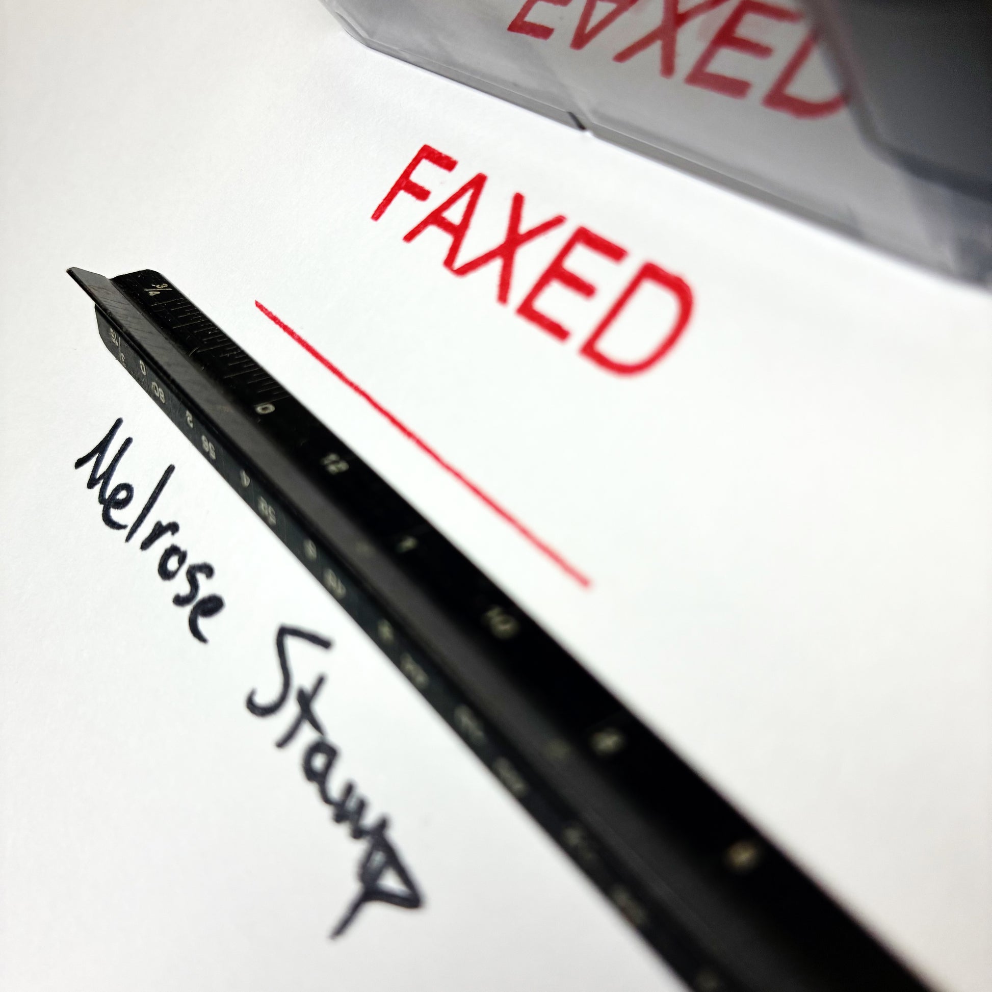 Close-up of a faxed document with 'Melrose Stamp' and 'FAXED' text.