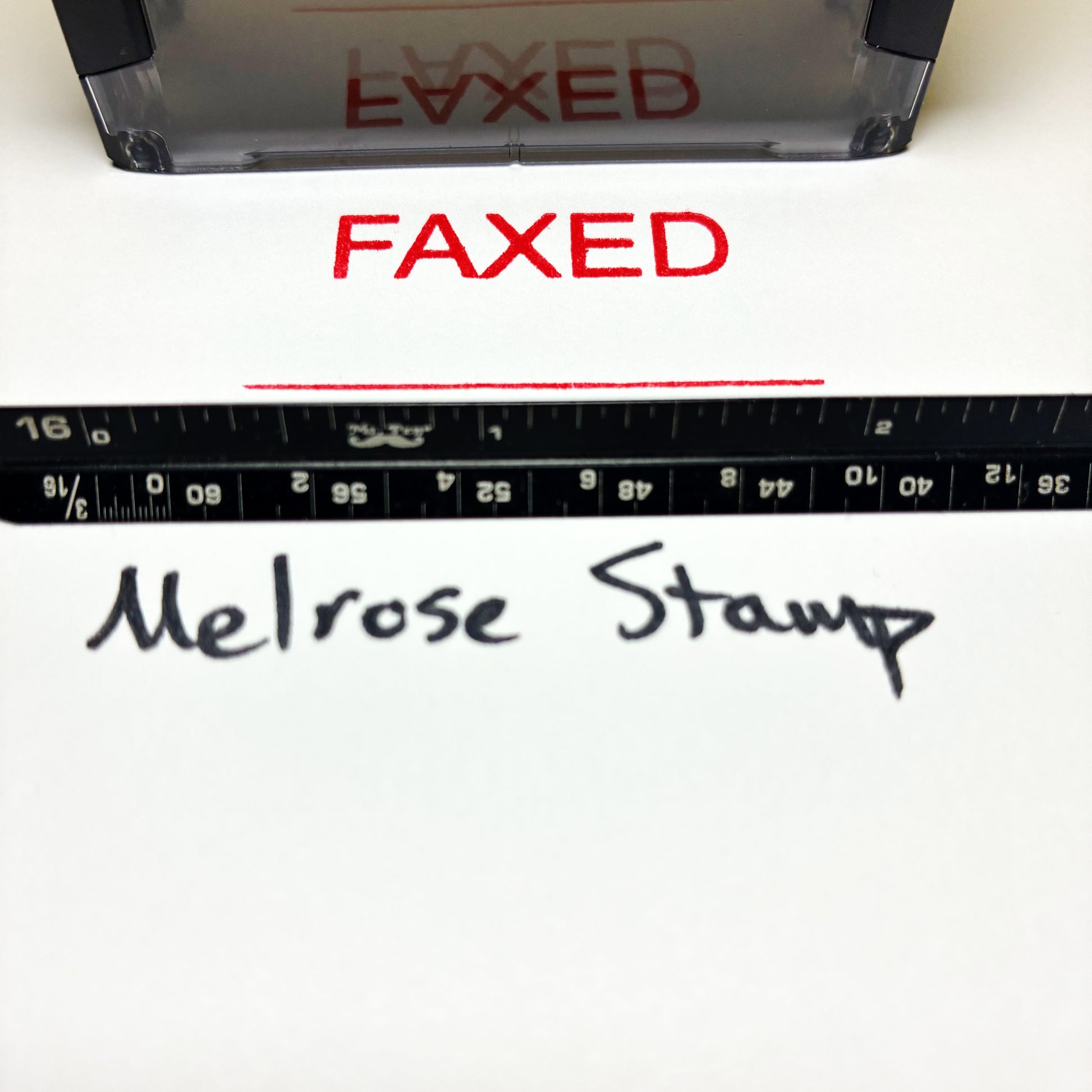 Red 'FAXED' stamp on paper with a ruler and 'Melrose Stamp' branding.