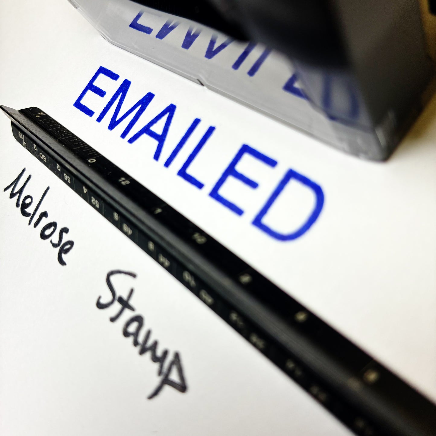 Close-up of a stamp with 'EMAILED' text and 'Melrose Stamp' branding.