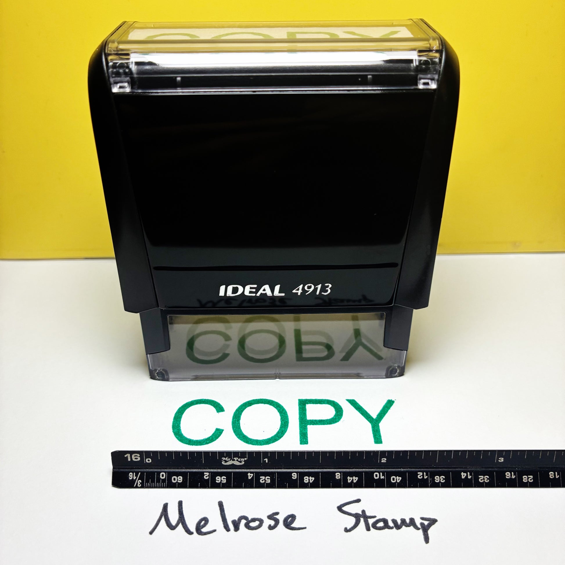 Ideal 4913 rubber stamp with 'COPY' text green ink on a white surface and yellow background