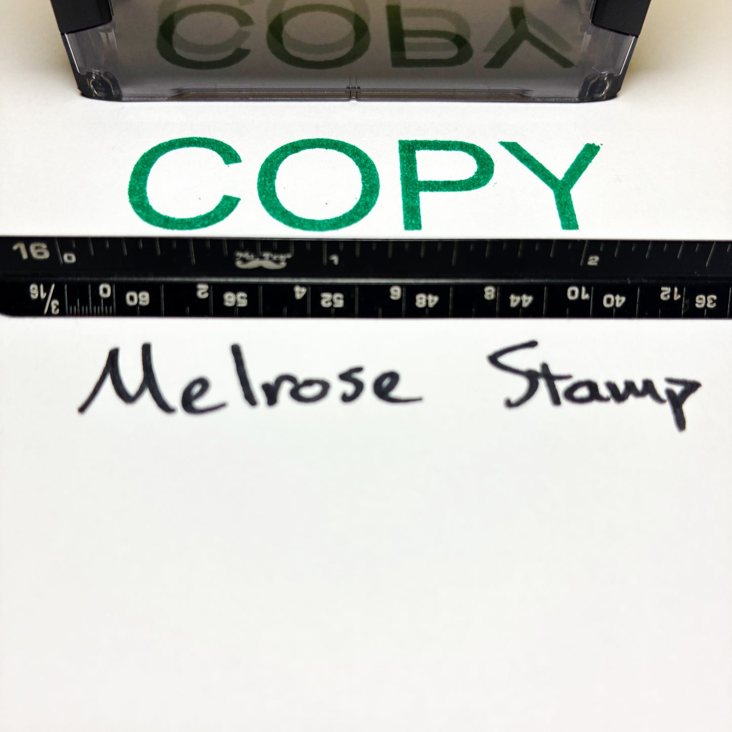 Rubber stamp with 'COPY' text and a ruler below on a white background