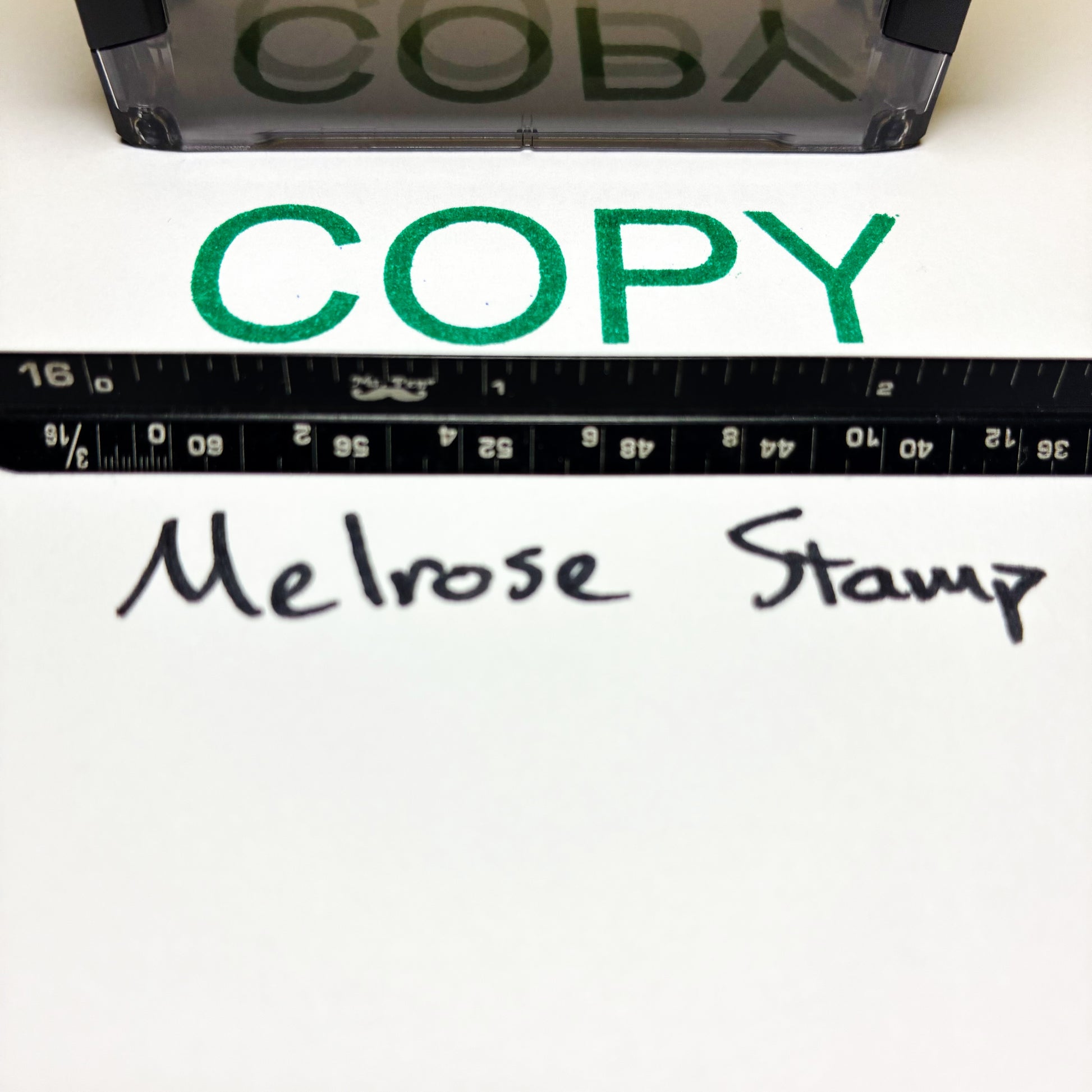 Rubber stamp with 'COPY' text and a ruler below on a white background