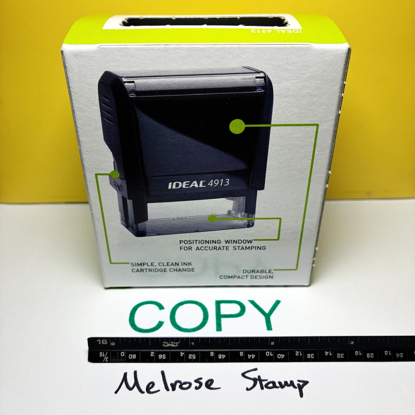 Box of Ideal 4913 stamp Copy in green ink on a white surface with a yellow background