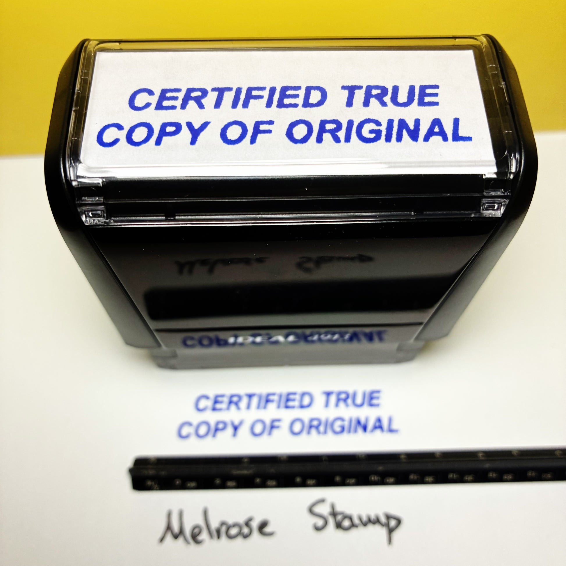 Stamp with 'CERTIFIED TRUE COPY OF ORIGINAL' text on a white surface with a yellow background.
