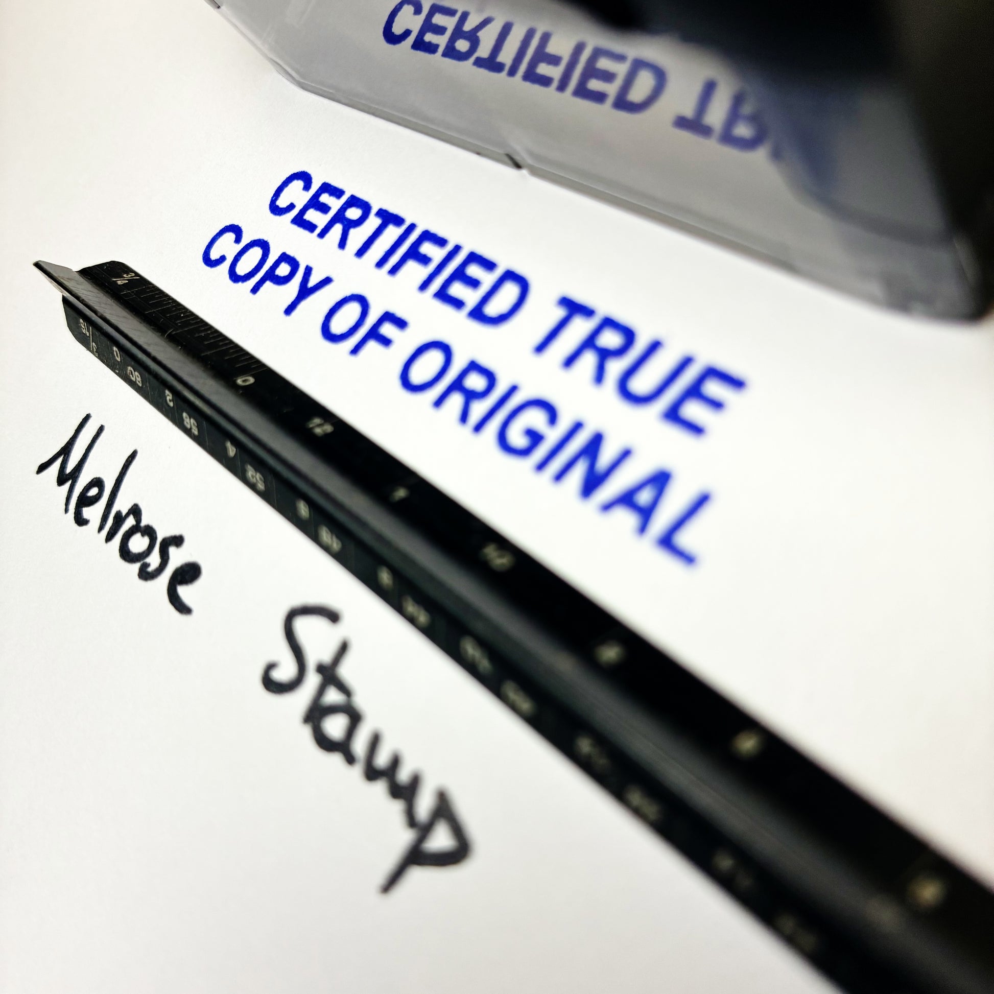 Close-up of a document with 'Certified True Copy of Original' text and a stamp
