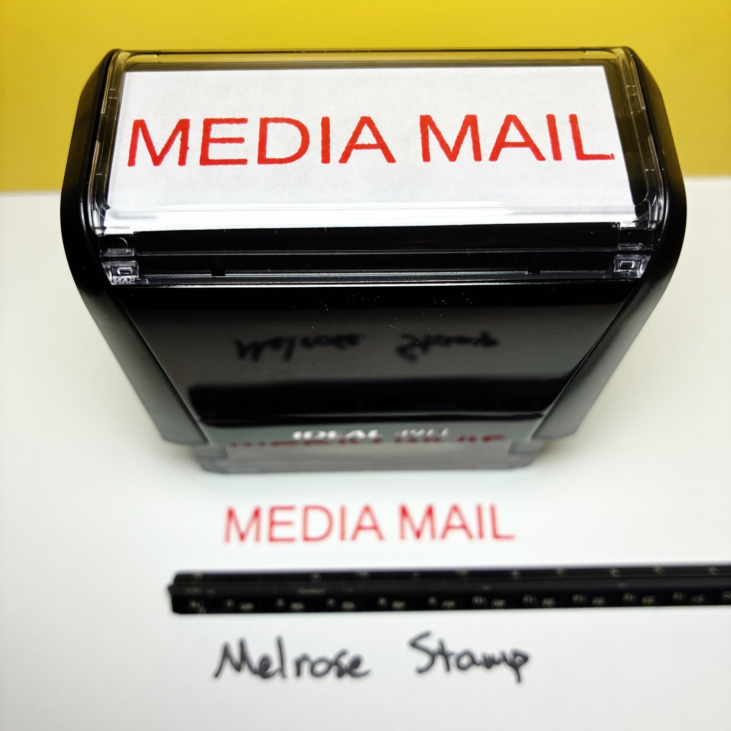 Rubber stamp with 'MEDIA MAIL' text on a white background