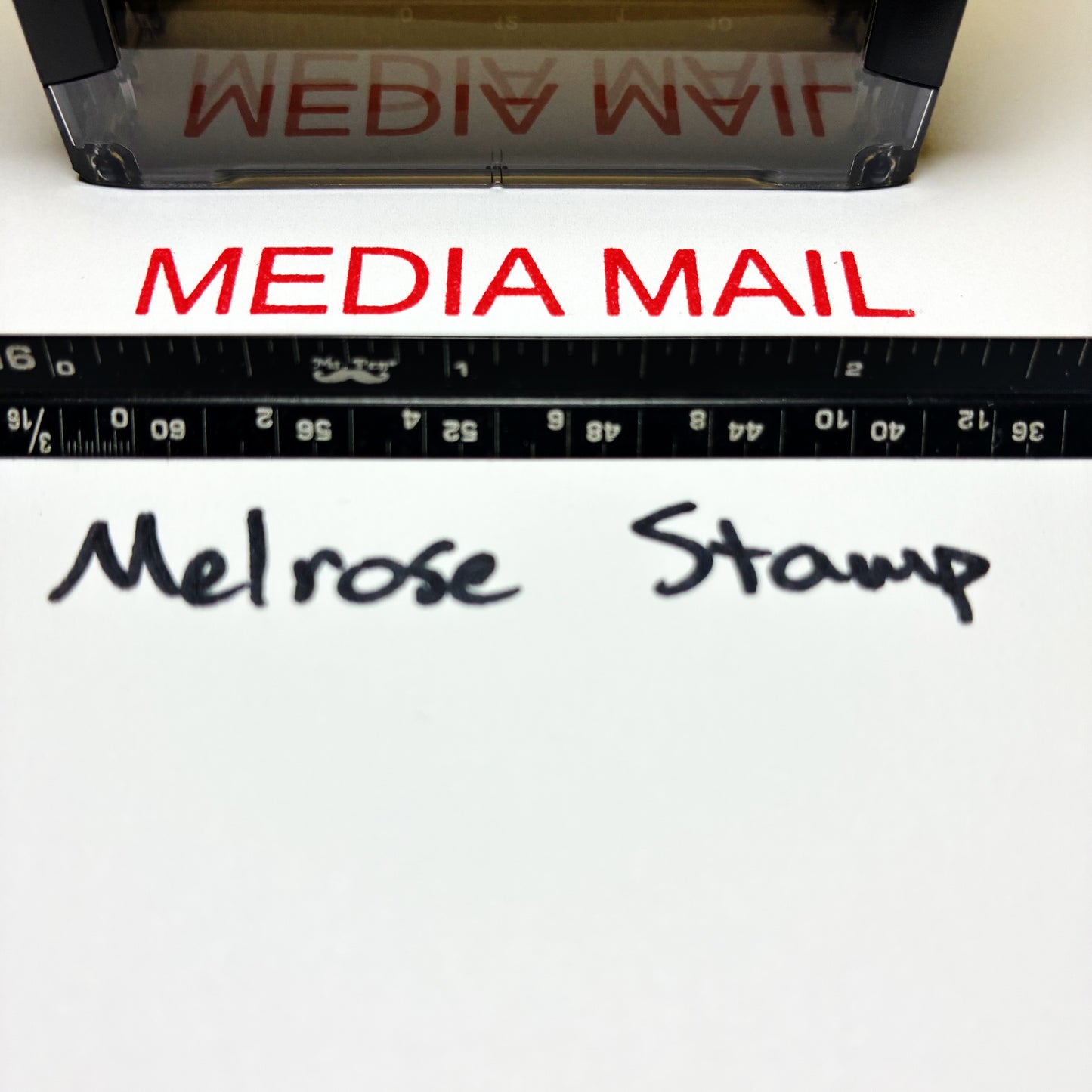 Media Mail stamp with a ruler and 'Melrose Stamp' text on a white background