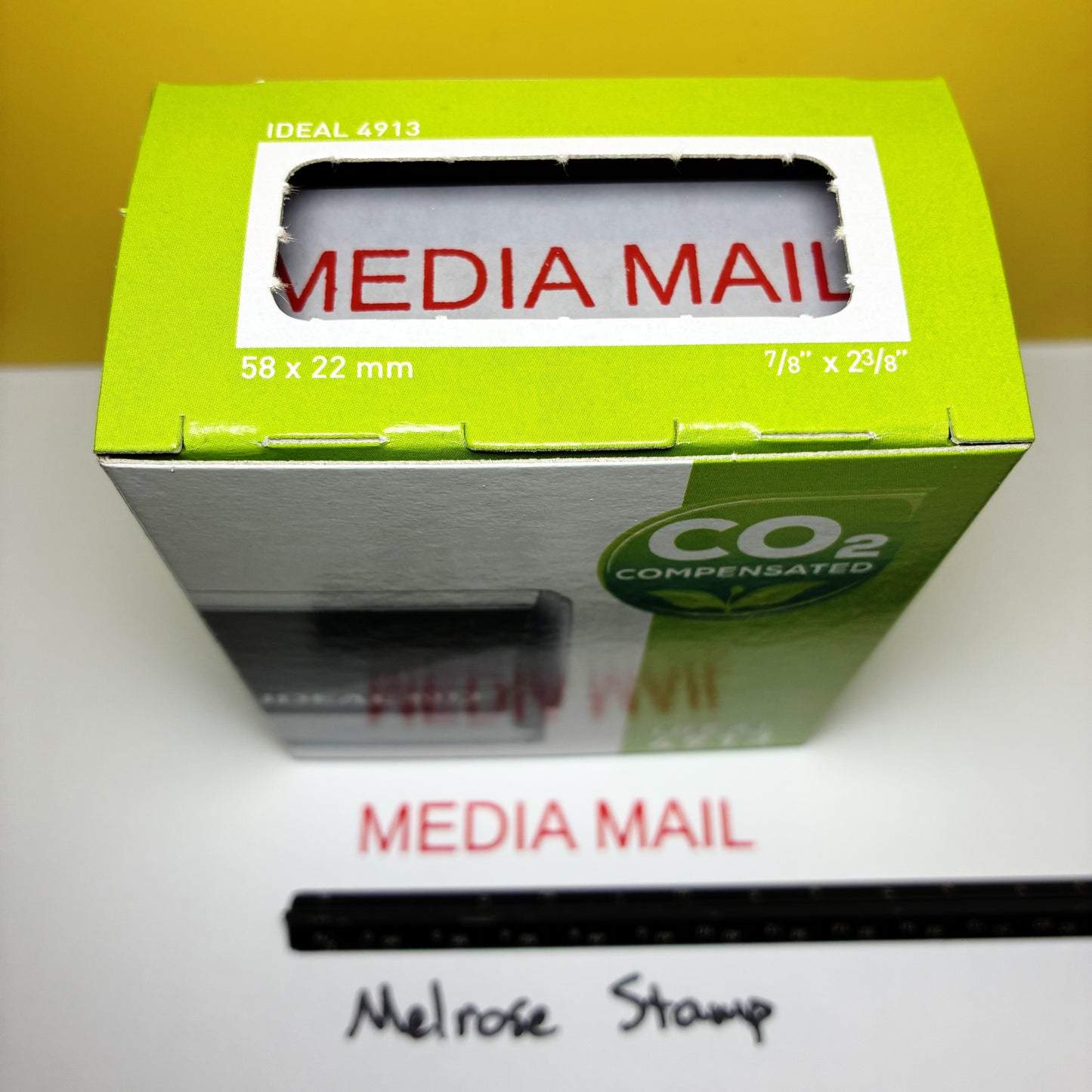 Green stamp box with 'Media Mail' text on a white surface