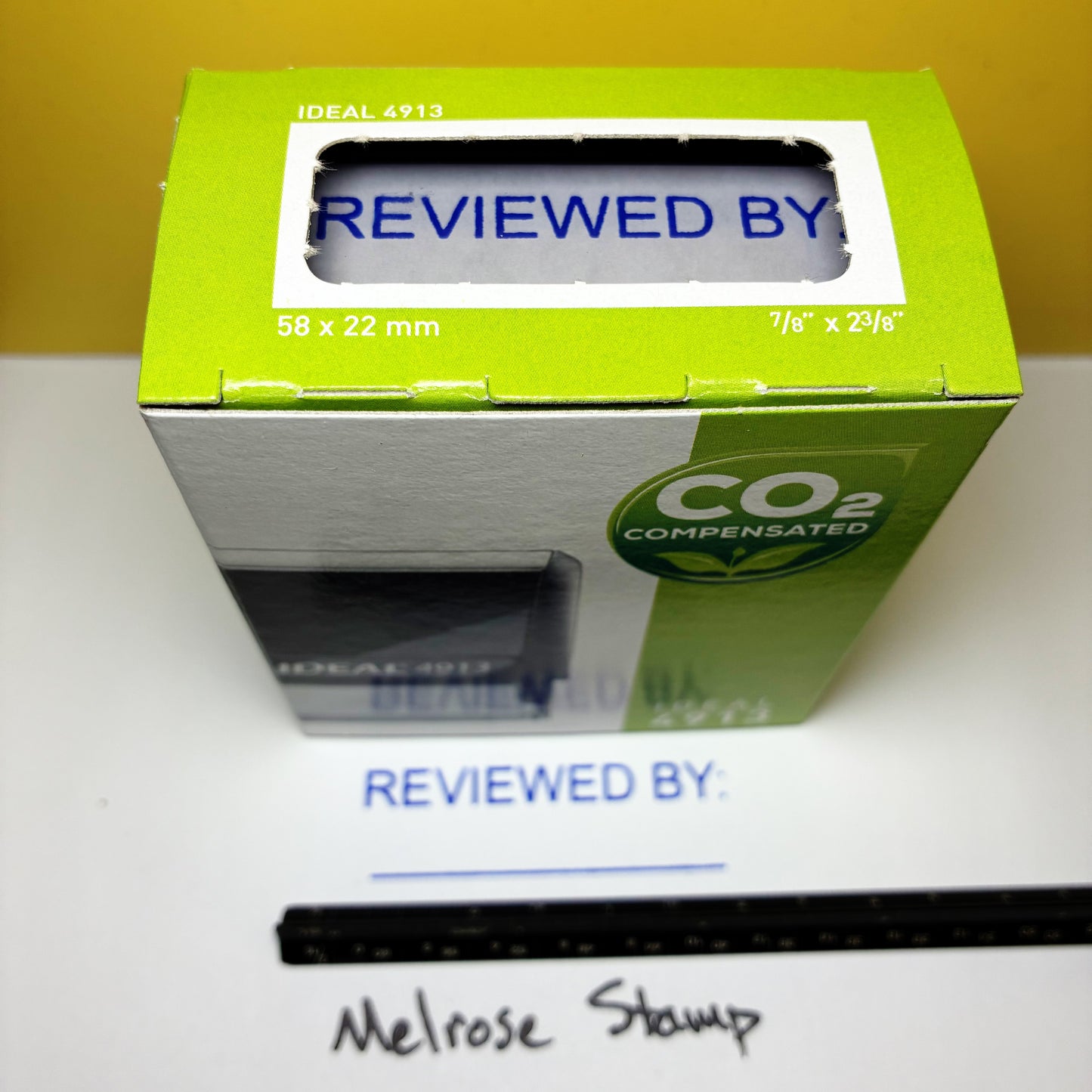 Green box, with 'REVIEWED BY' text  rubber stamps blue ink and a ruler.