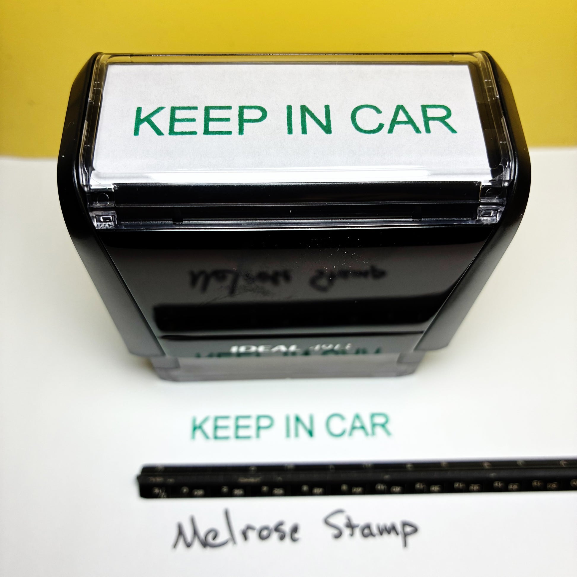 Stamp with 'KEEP IN CAR' text and a ruler for size reference on a white background.