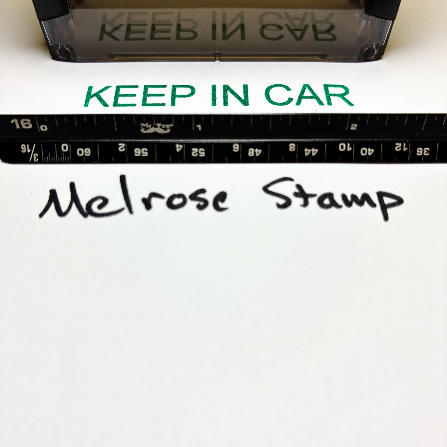 Stamp with 'KEEP IN CAR' text and a ruler below it on a white background