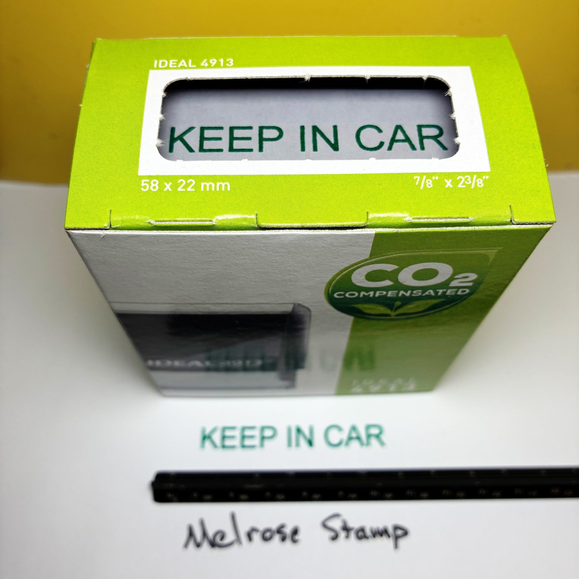 Green and silver box with 'Keep in Car' text on a white surface