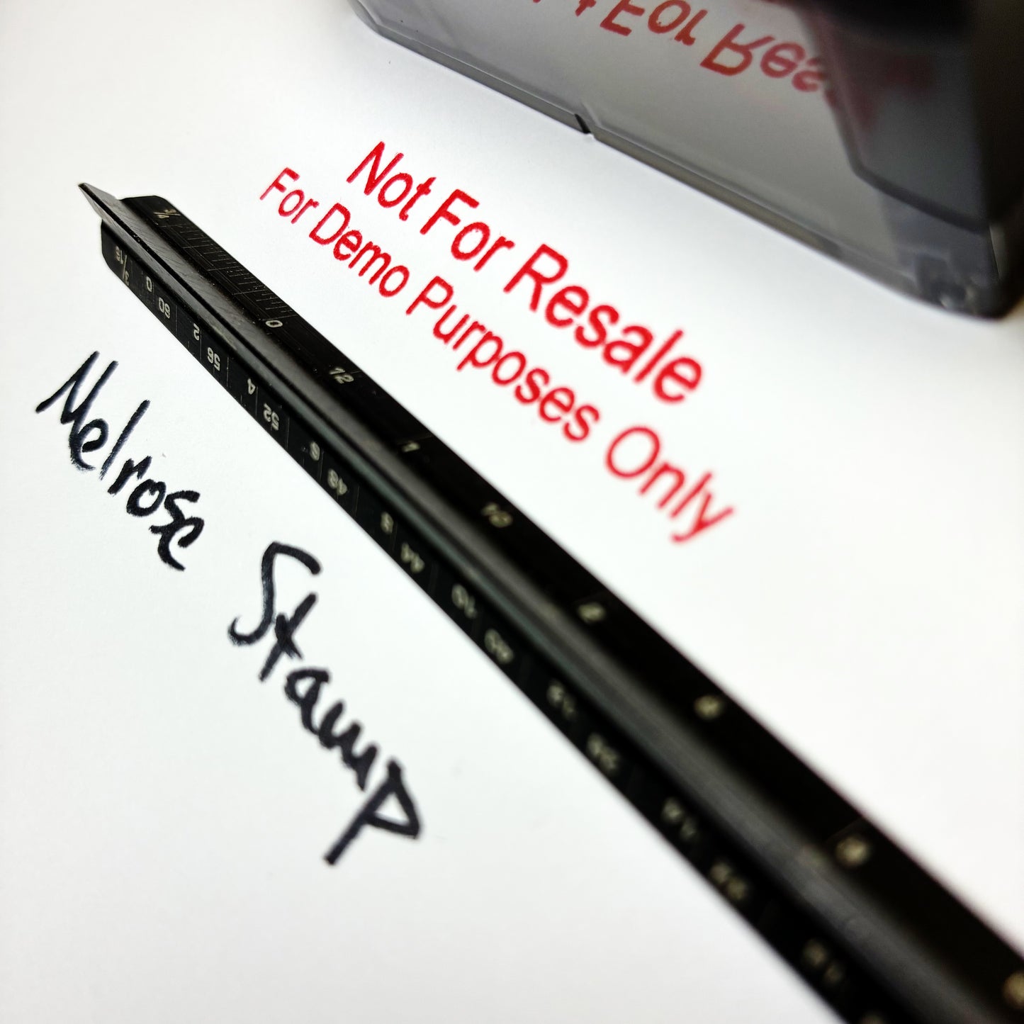 A close-up of a black rubber stamp impression on white paper, showing a handwritten black ink signature and red text reading 'Not For Resale For Demo Purposes Only.' A second stamp is partially visible at the top right.