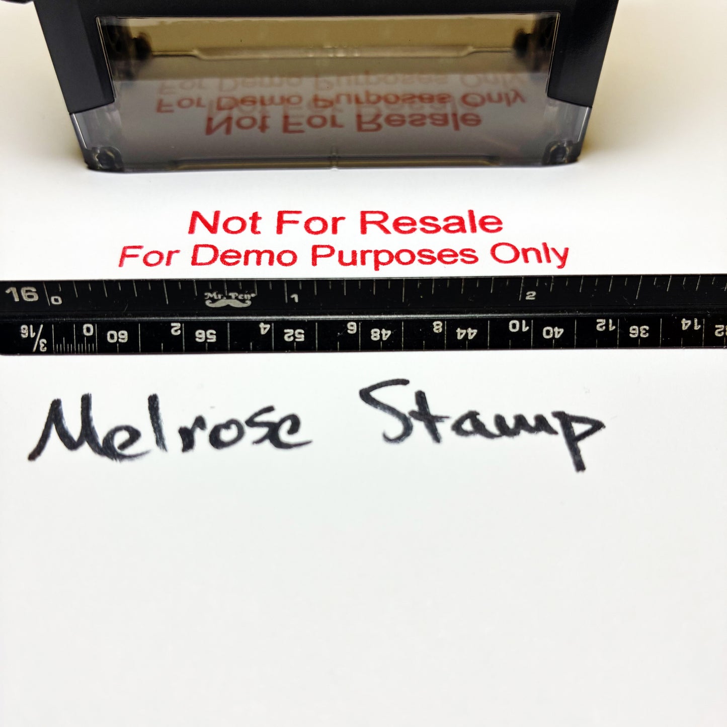 A Melrose stamp shown with a black measuring tape and handwritten sample text on a white surface. Red text across the middle reads 'Not For Resale For Demo Purposes Only'.