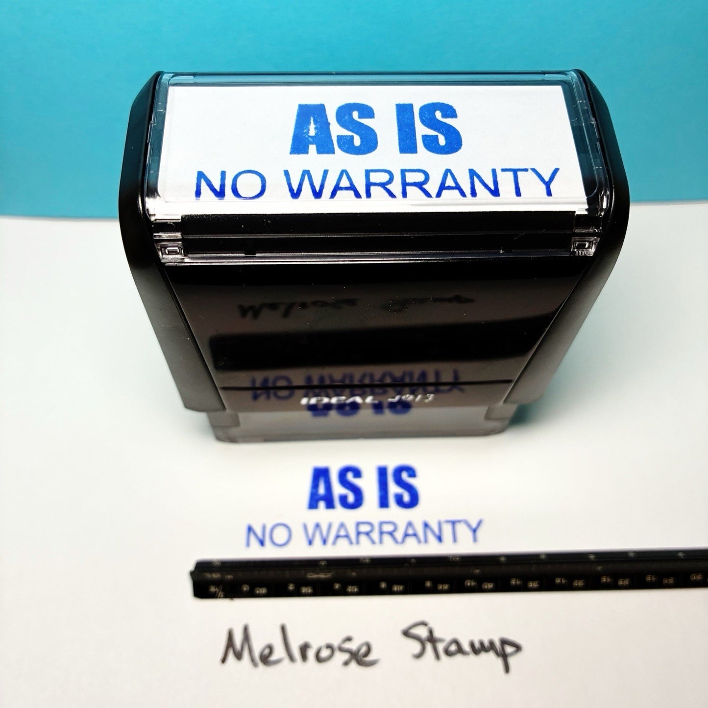Stamp with 'AS IS NO WARRANTY' text on a white surface with blue background