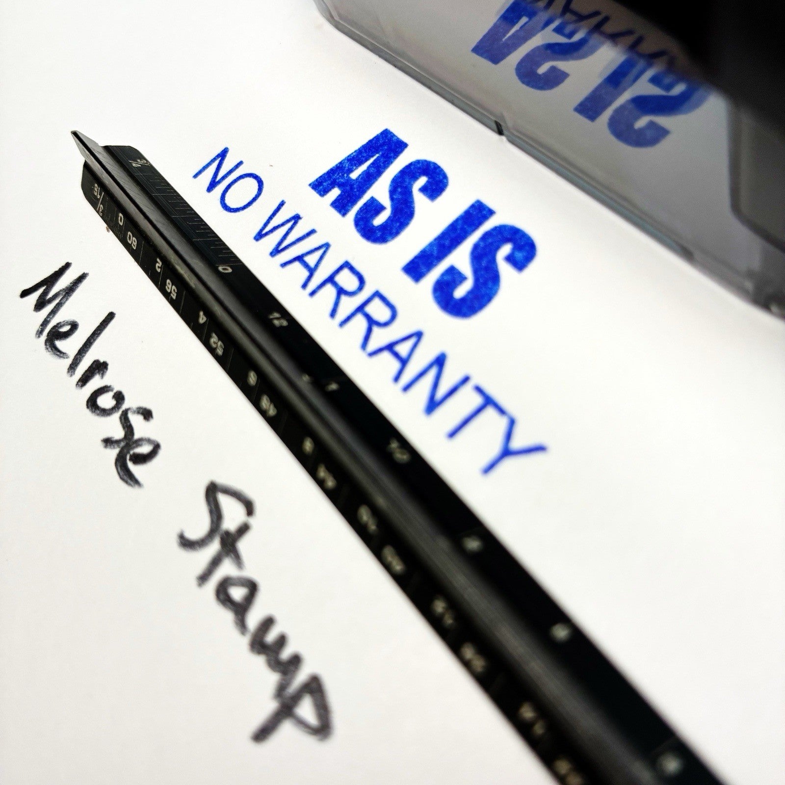 Black stamp with 'AS IS NO WARRANTY' text on a white background