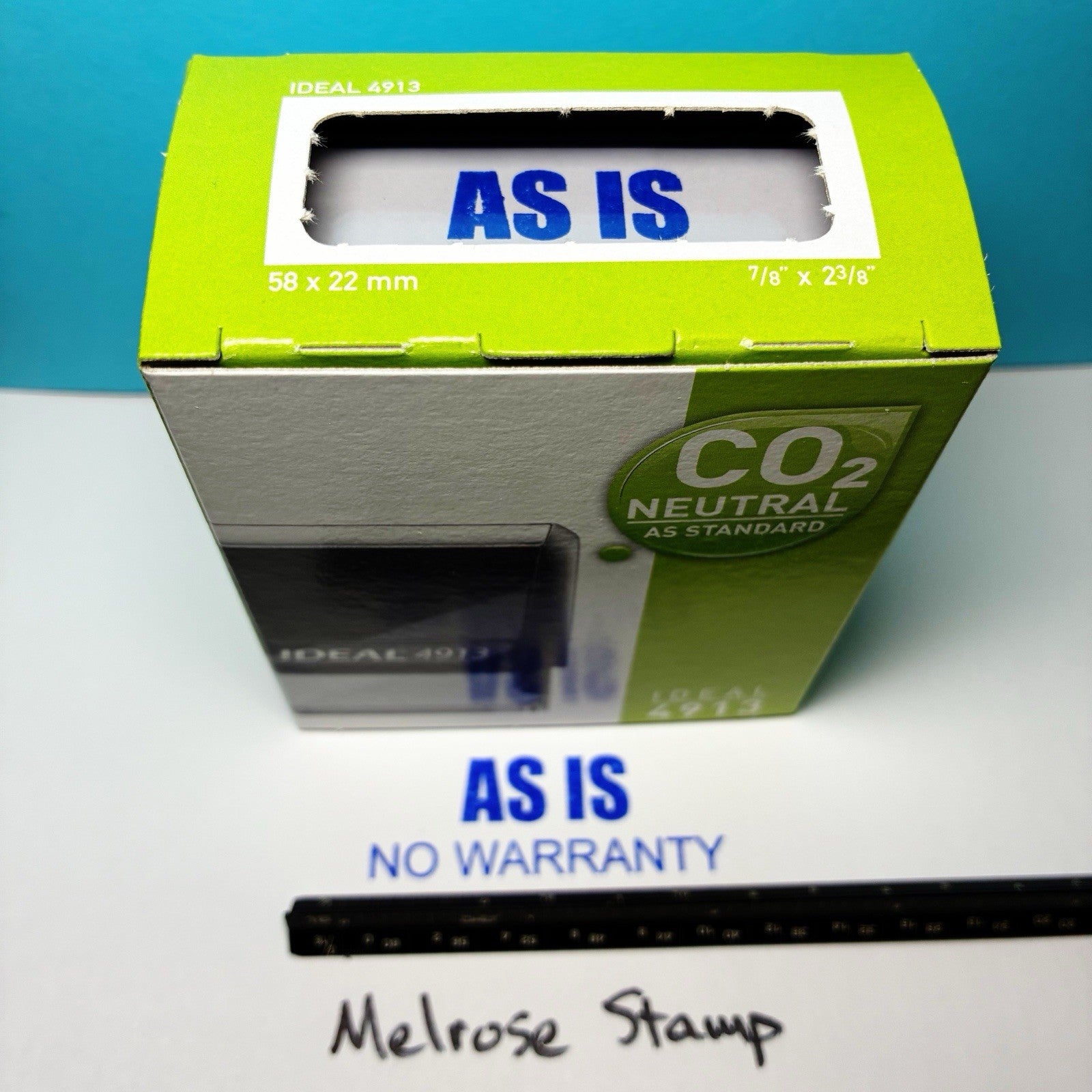 Green box labeled 'AS IS' with a ruler for scale on a white surface.