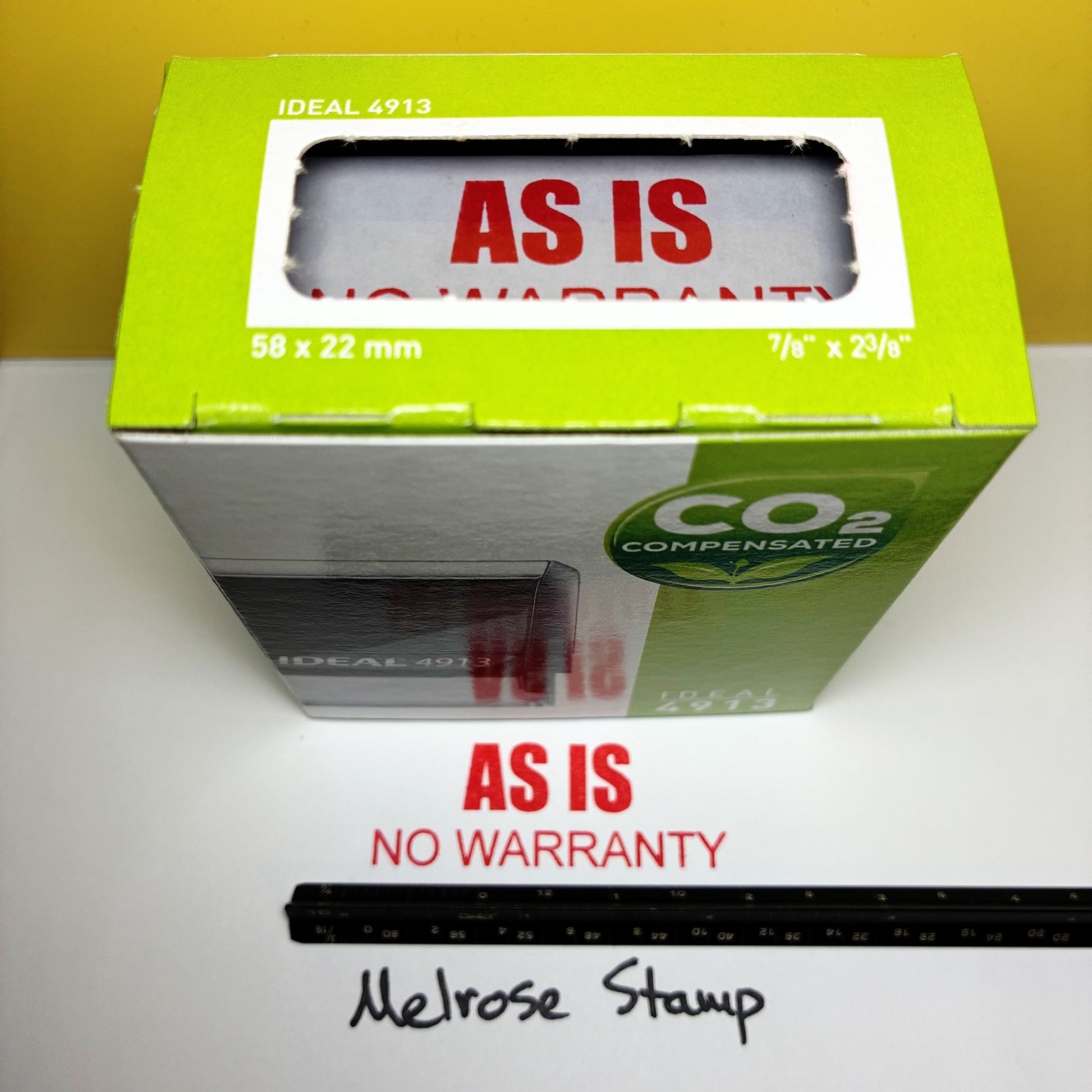 Green box with 'As Is No Warranty' rubber stamp on a white surface