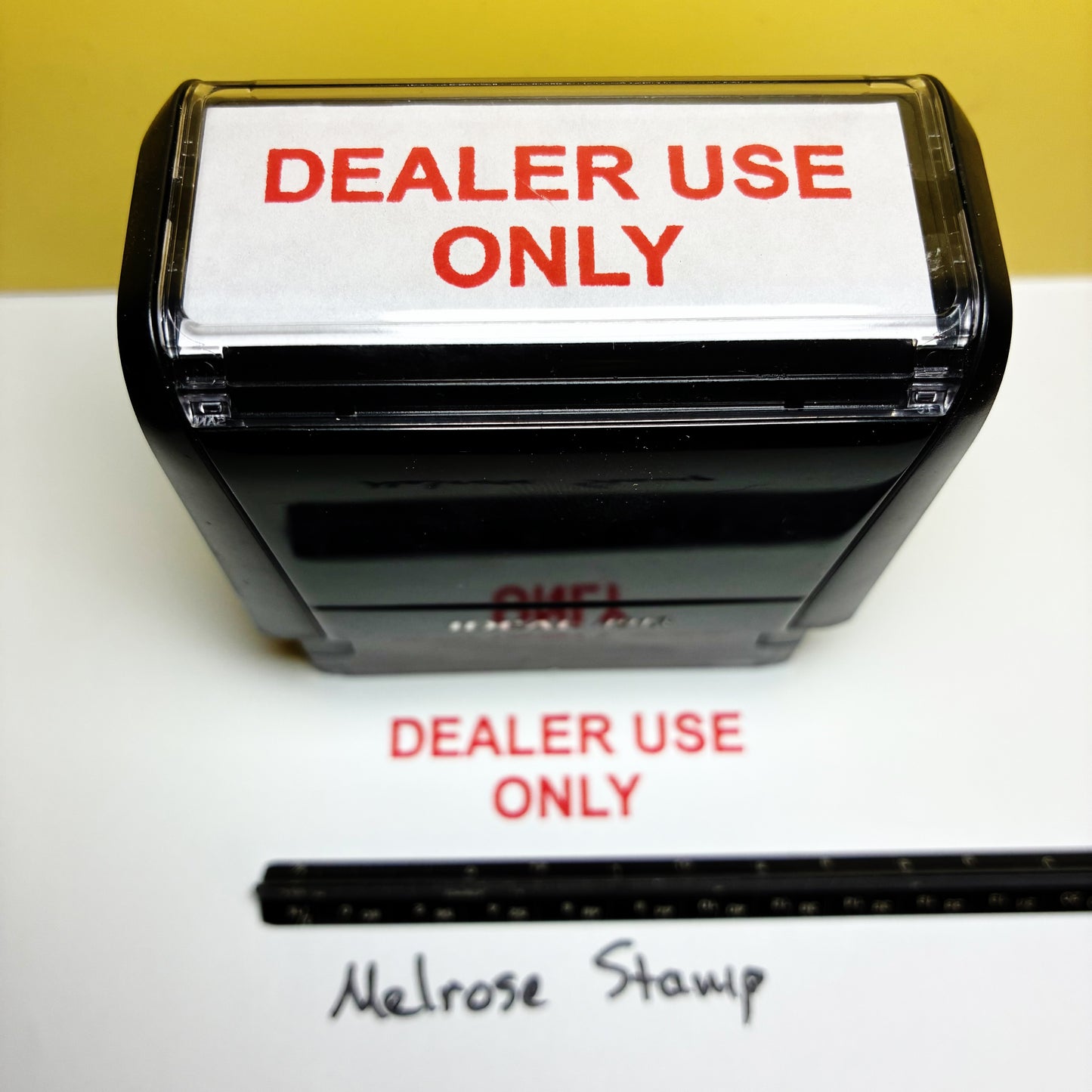 Stamp with 'DEALER USE ONLY' text on a white surface with a yellow background