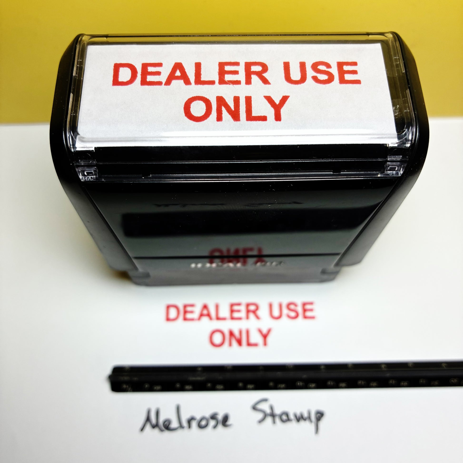 Stamp with 'DEALER USE ONLY' text on a white surface with a yellow background