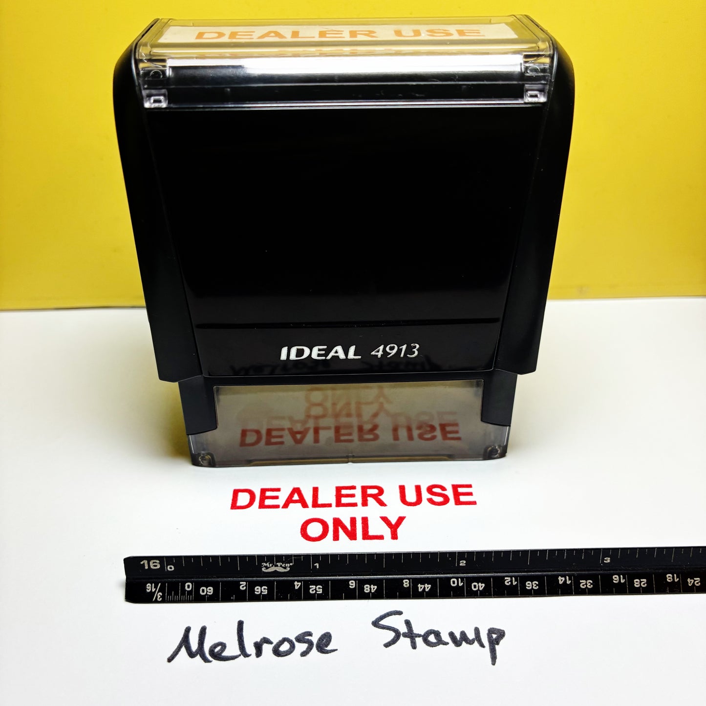 Black stamp with 'DEALER USE ONLY' text on a yellow and white background, accompanied by a ruler for scale.