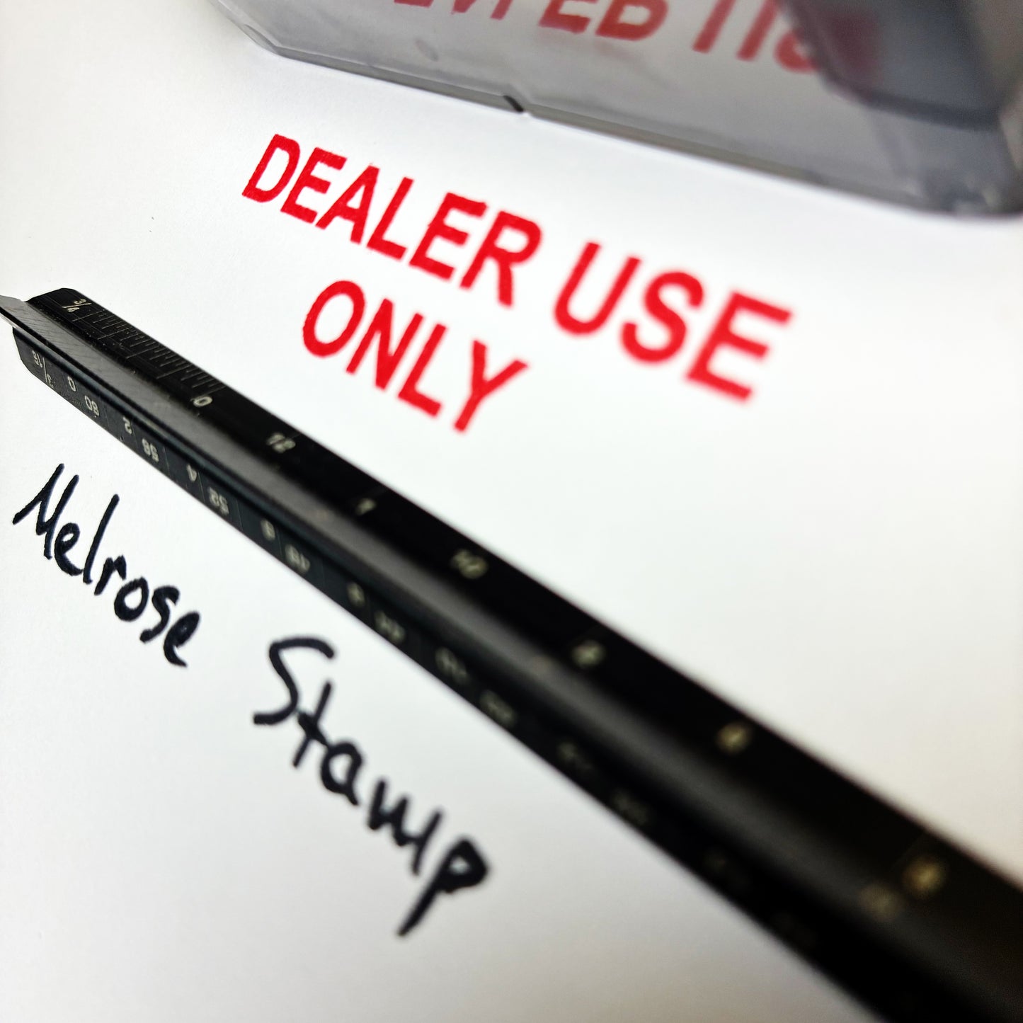 Black stamp with 'Melrose Stamp' and 'DEALER USE ONLY' text on a white background
