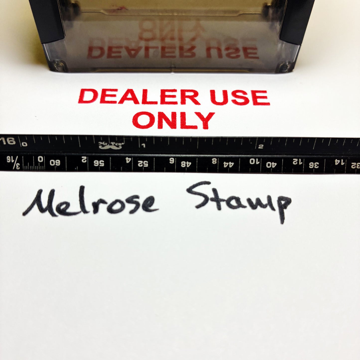 Stamp with 'DEALER USE ONLY' text and a ruler below, on a white background.