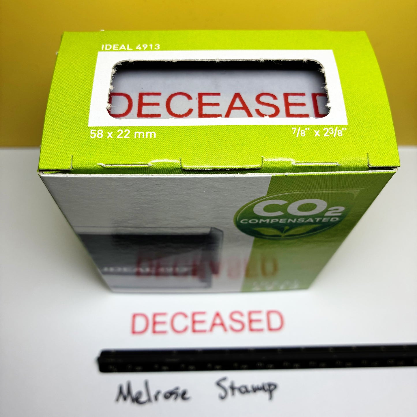 Green stamp box with 'DECEASED' text on a white surface
