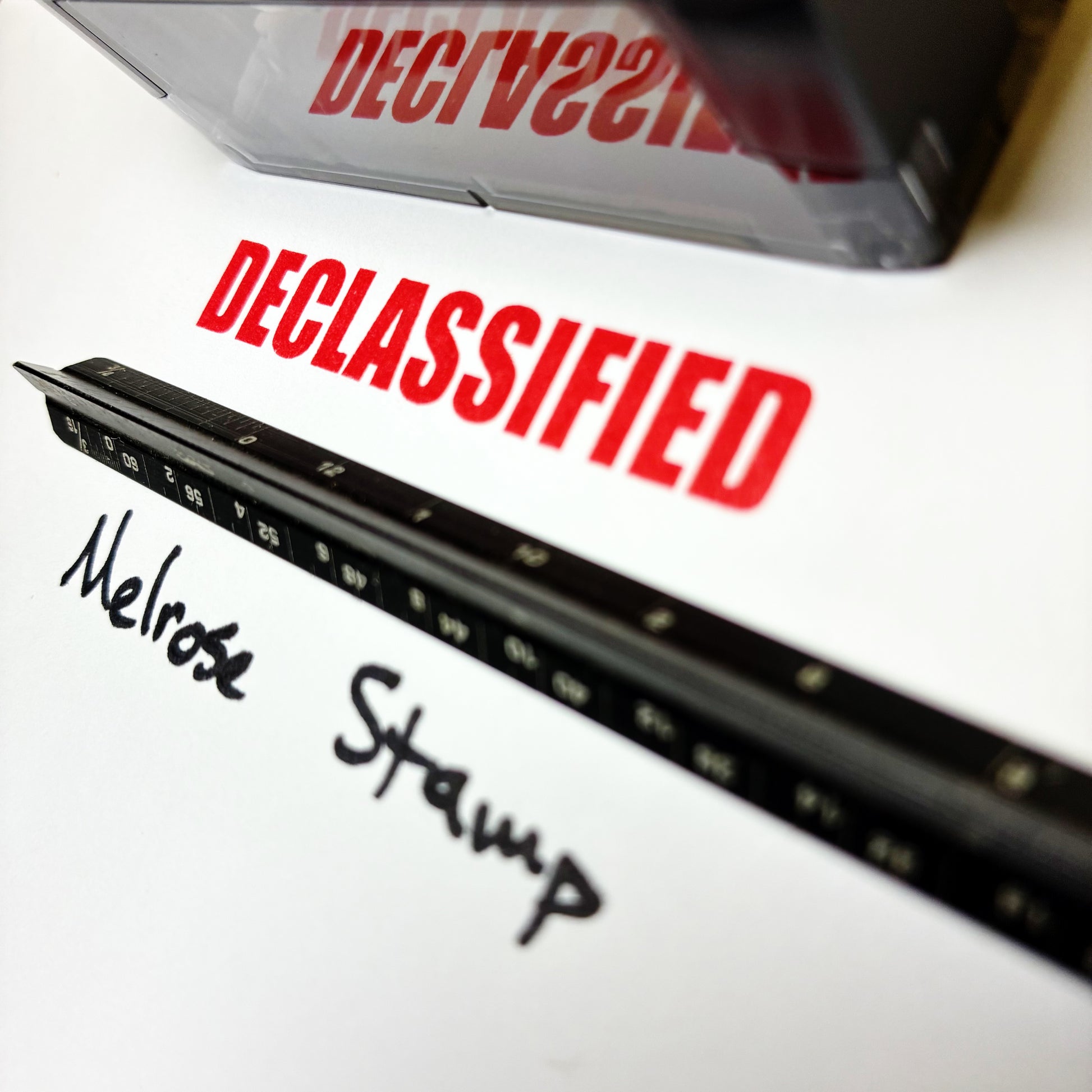 Declassified stamp on a document with 'Melrose Stamp' branding.