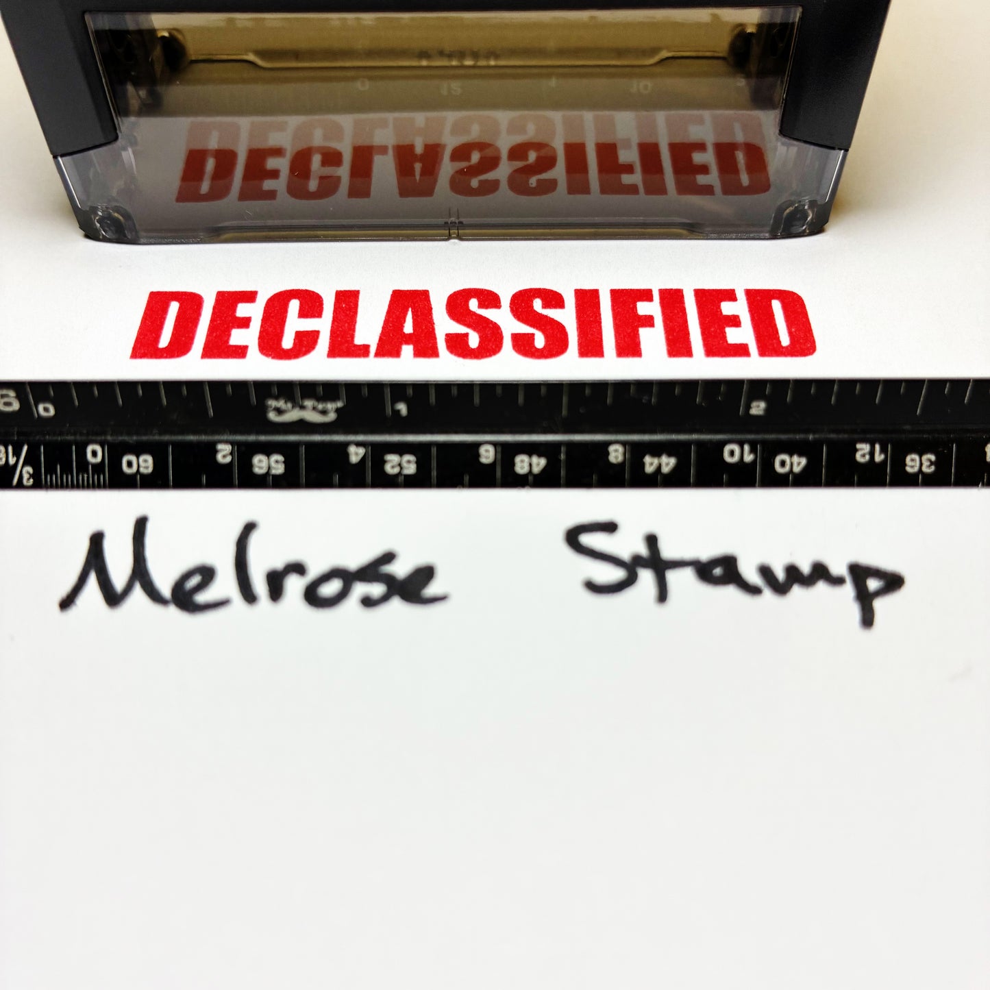 Declassified stamp with a ruler and 'Melrose Stamp' text on a white background