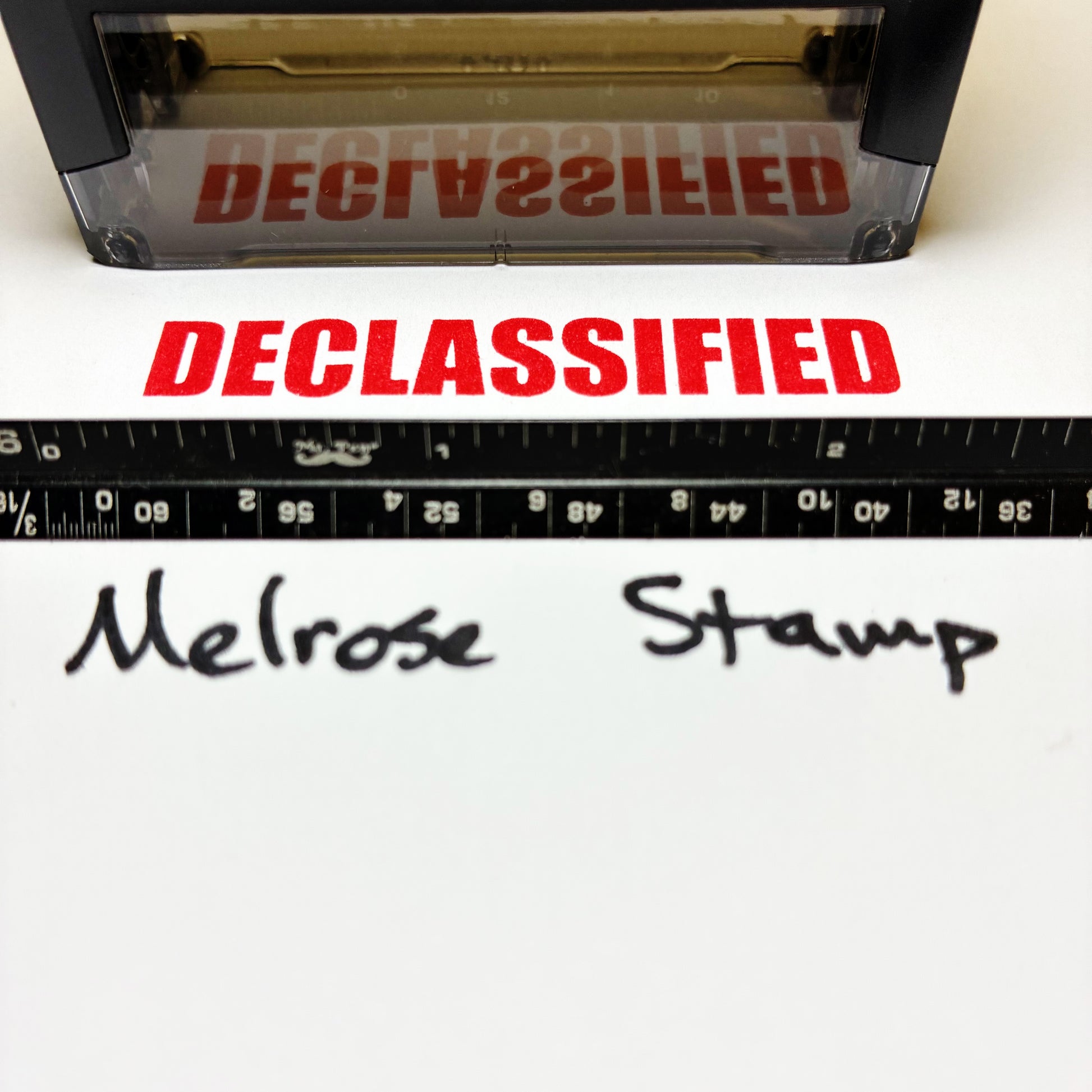 Declassified stamp with a ruler and 'Melrose Stamp' text on a white background
