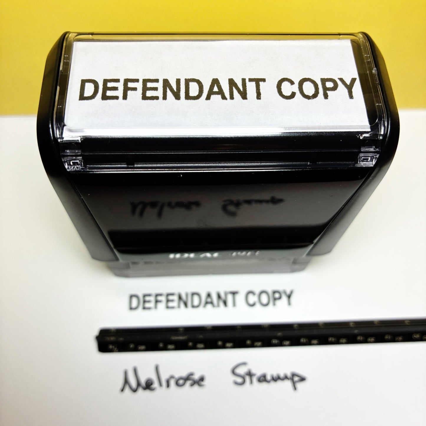 Stamp with 'DEFENDANT COPY' text on a white surface, with a yellow background.